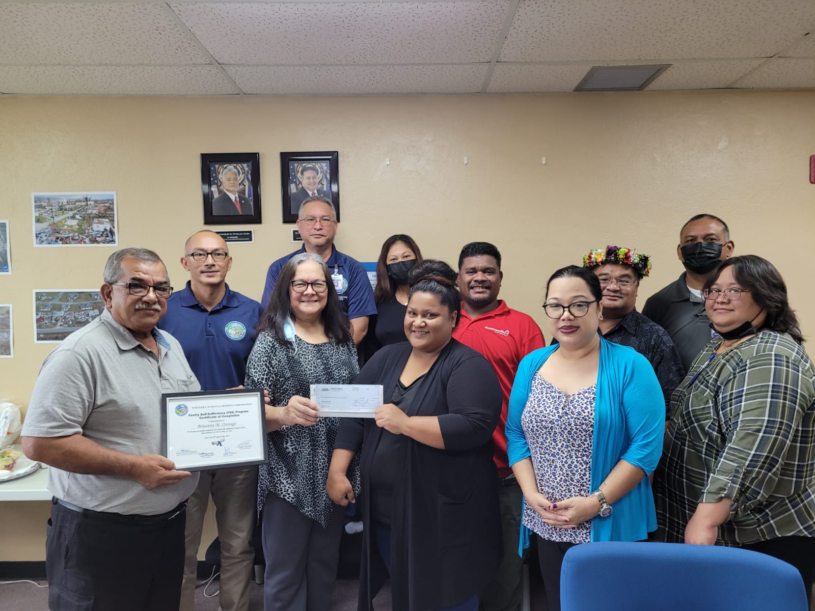 Breanna Oronigo, the first graduate of Northern Marianas Housing Corp.’s Family Self-Sufficient Program, poses for a photo with NMHC officials.
