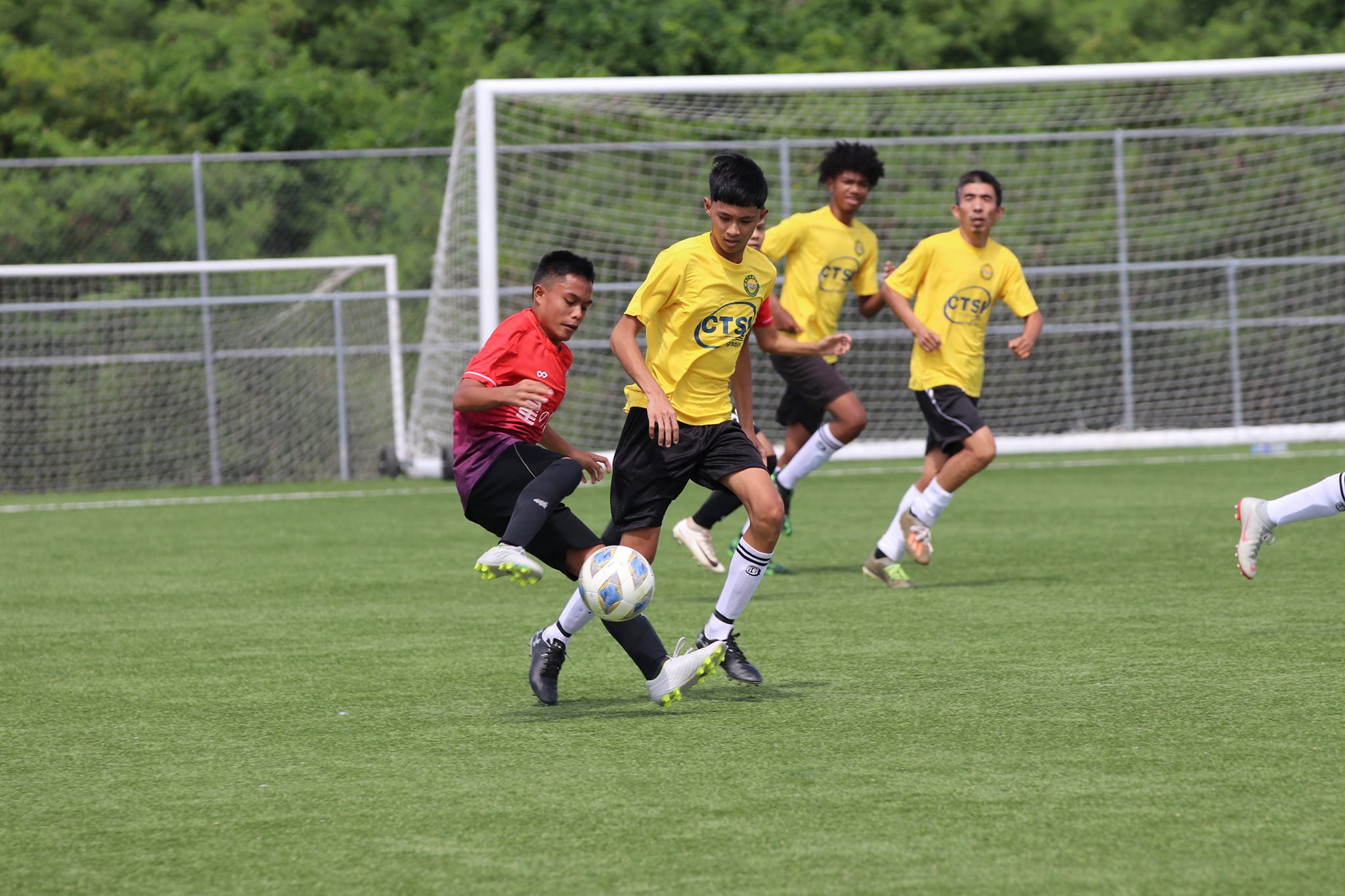 An Island Star player tries to shake off a defender during a Marianas Soccer League 2 game Sunday at the NMI Soccer Training Center.