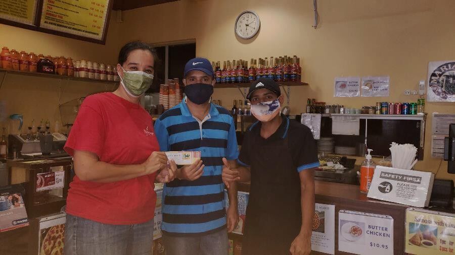Tournament committee member Catherine Perry, left, receives a donation of gift certificates on July 29, 2021, from Java Joe’s for the 19th Annual HANMI Charity Classic Golf Tournament slated for Aug. 14, 2021, at Coral Ocean Golf Resort on Saipan. 