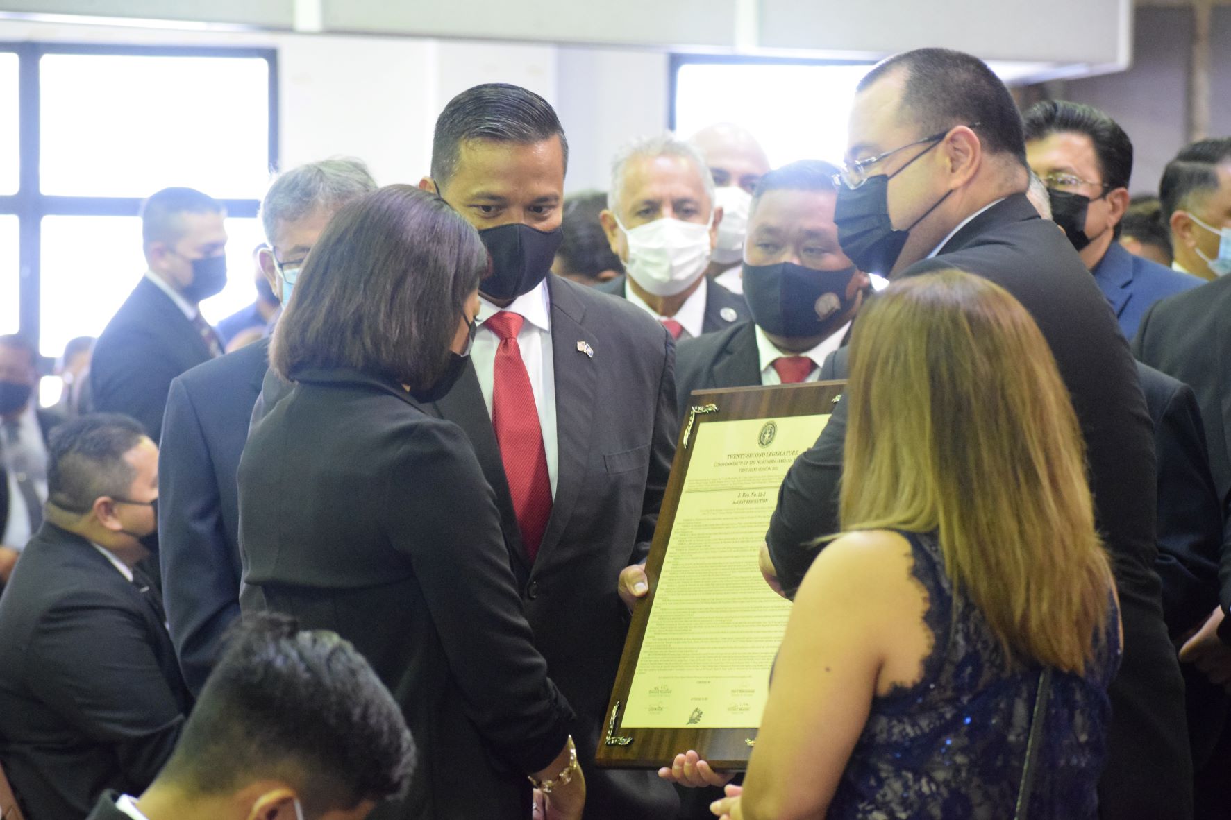 Senate President Jude U. Hofschneider and Speaker Edmund S. Villagomez present a legislative tribute to the family of Rep. Ivan Blanco.