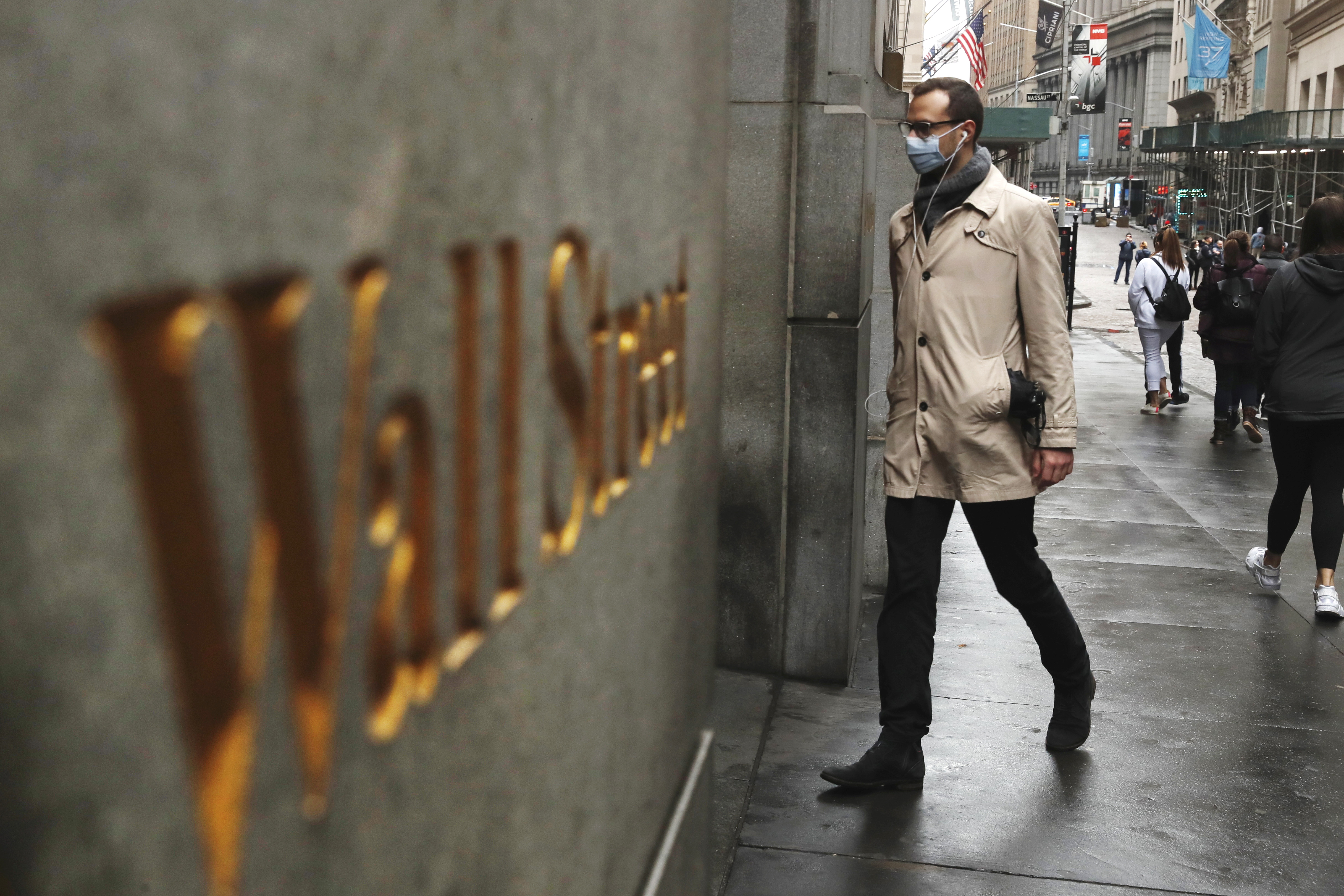A man wears a protective mask as he walks on Wall Street during the coronavirus outbreak in New York City on March 13, 2020.