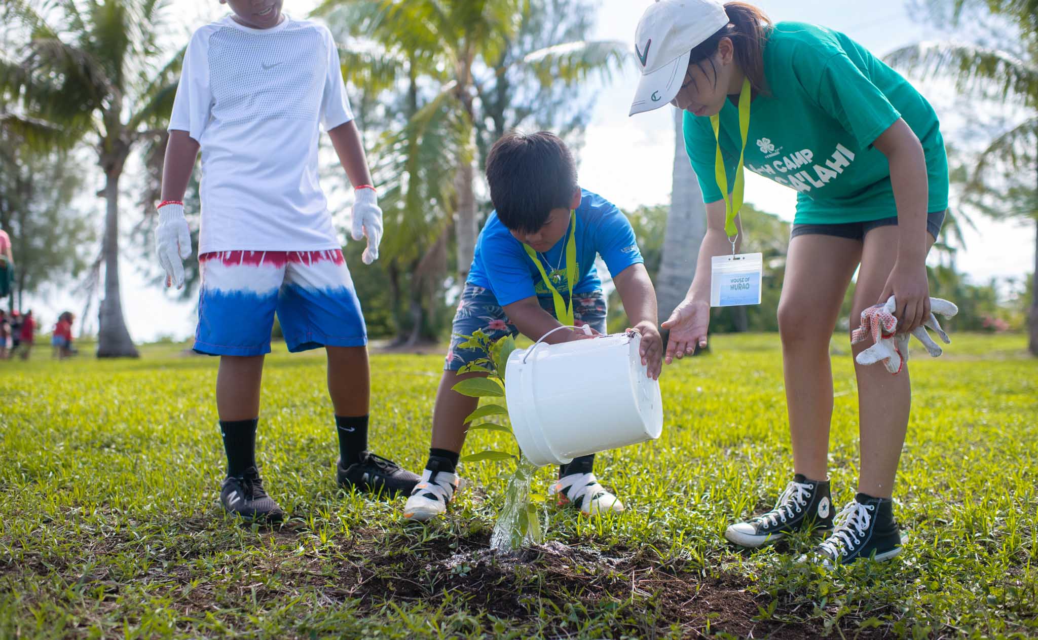A Department of Land and Natural Resources staff member shows campers how to properly plant a tree at Taga Beach.