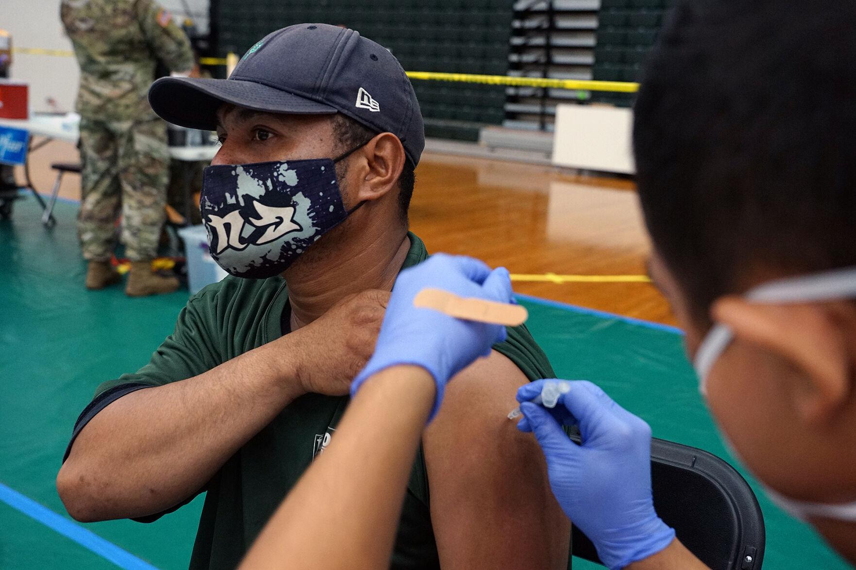 Tenison Llemelong, an administrative specialist from Securitas Security Services Inc., receives his first Pfizer-BioNTech Covid-19 vaccination at the University of Guam Calvo Field House in Mangilao on Saturday.