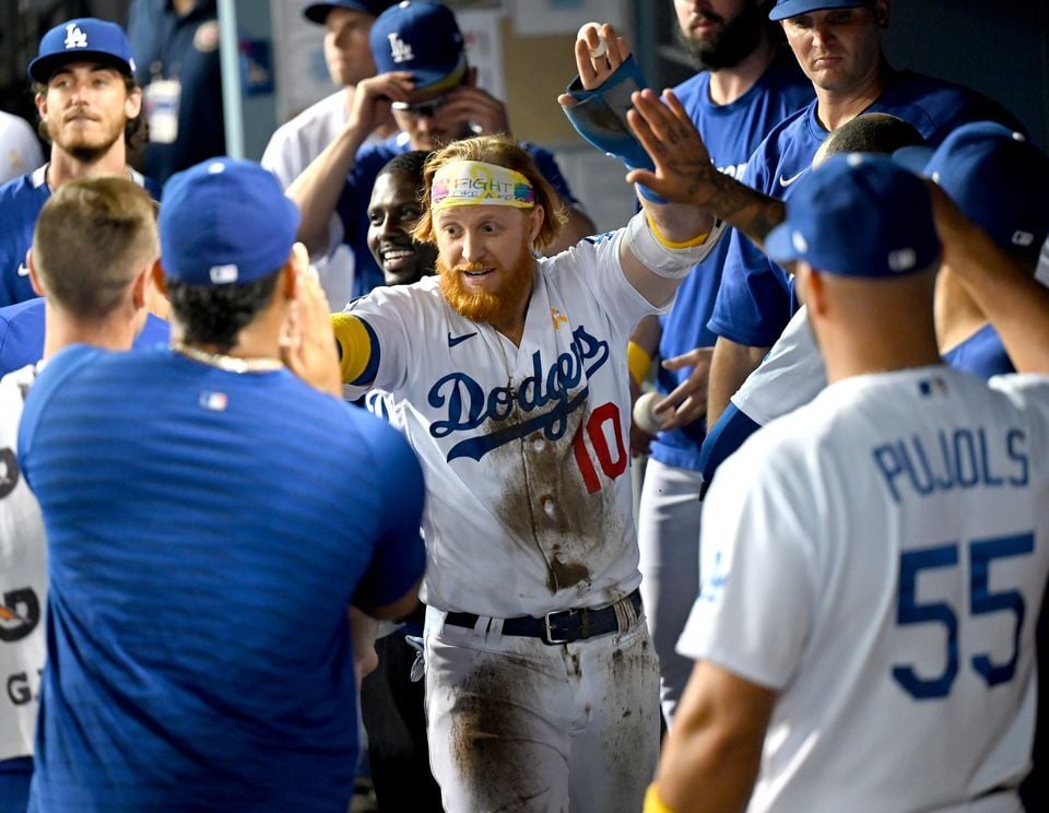 Los Angeles Dodgers third baseman Justin Turner (10) gets high fives in the dugout after scoring a run in the eighth inning against the Atlanta Braves at Dodger Stadium in Los Angeles, California on Sept. 1, 2021.