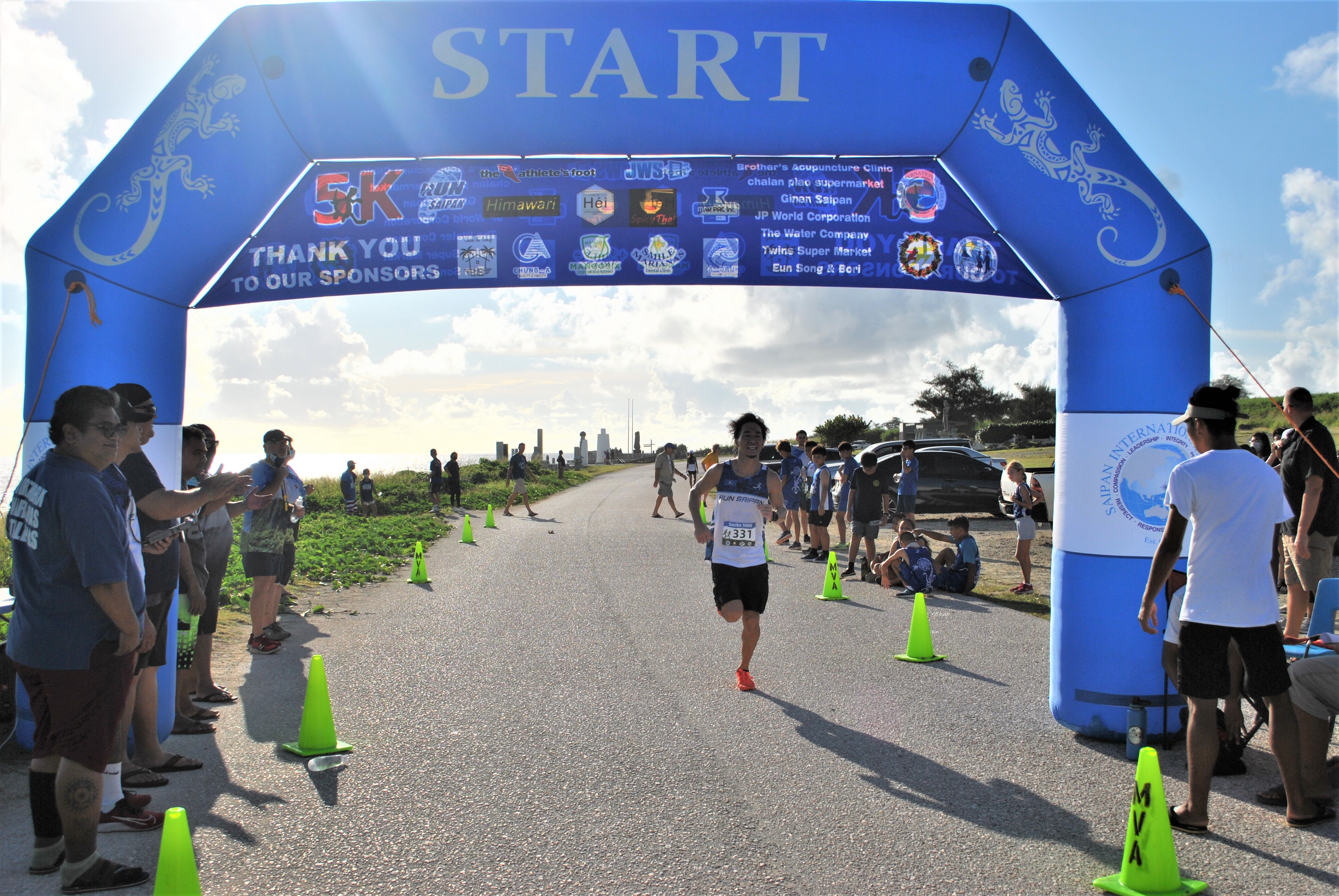 Shuji Kuroda smiles as he crosses the finish line of the Gecko 5000 Men's 8K run on Saturday at  Banzai Cliff.