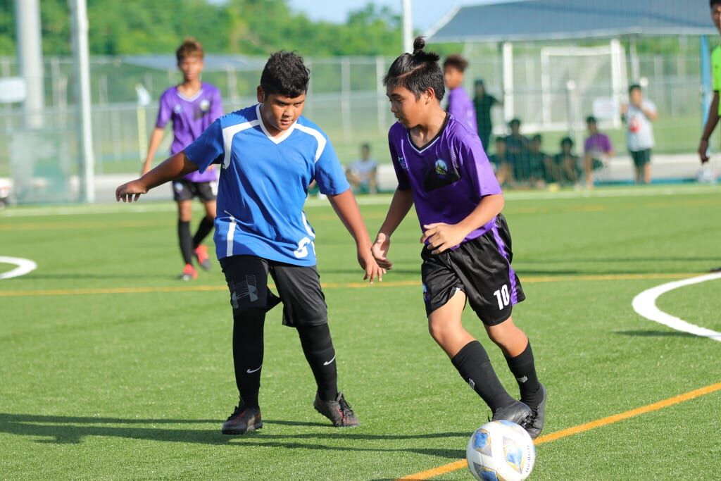 A Hopwood player takes possession against a defender during an NMIFA-PSS Interscholastic Soccer League game at the NMI Soccer Training Center on Tuesday.