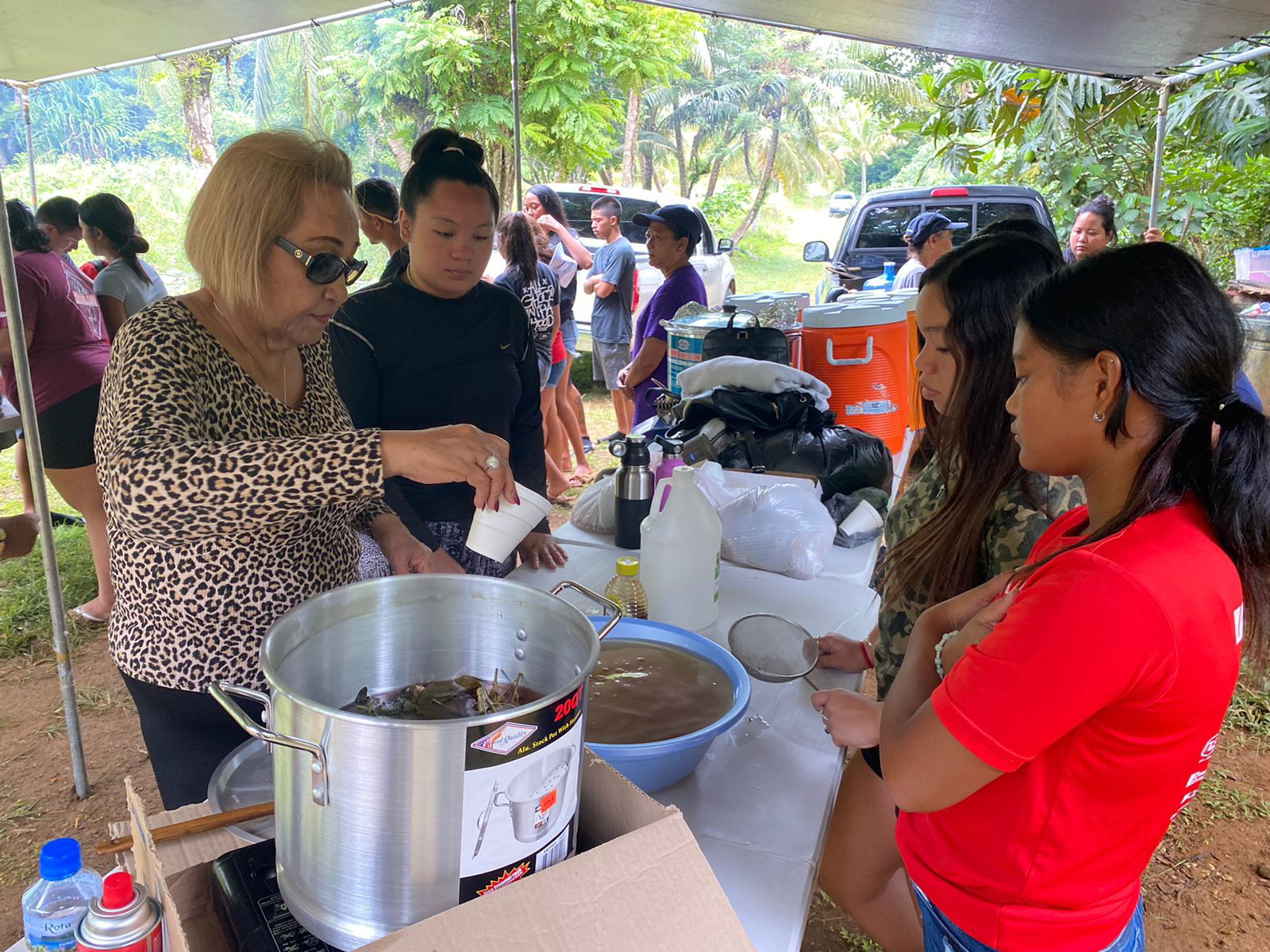 Lourdes Manglona, also known as “Mama Lou,” guides the youth through the process of making åmot kabadiyu, which the youth drank throughout the camp to boost their immune systems.