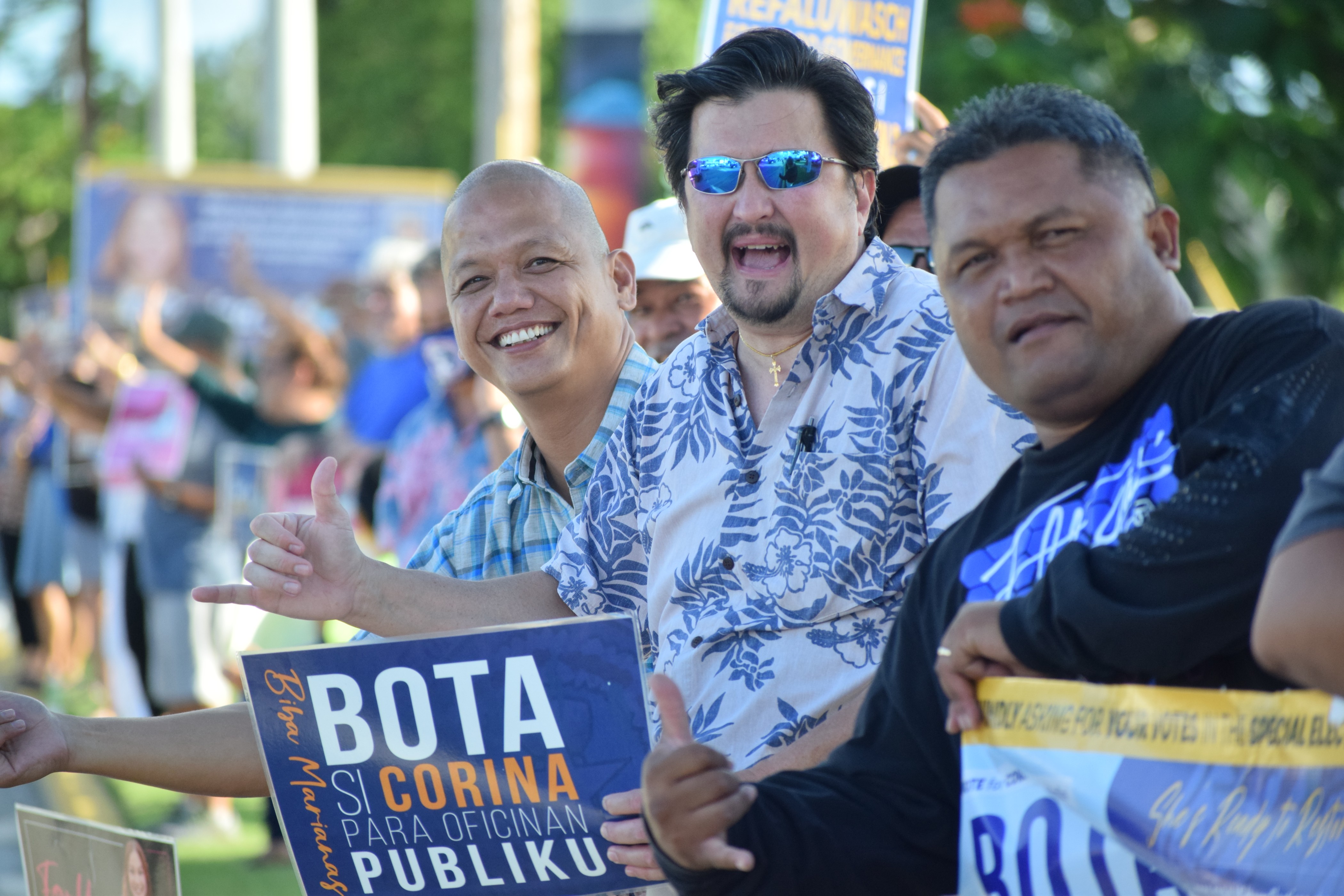 Rep. Edwin Propst, center, Vince S. Aldan, left, and Propst's hard-working community worker Sal Limes gesture at motorists.