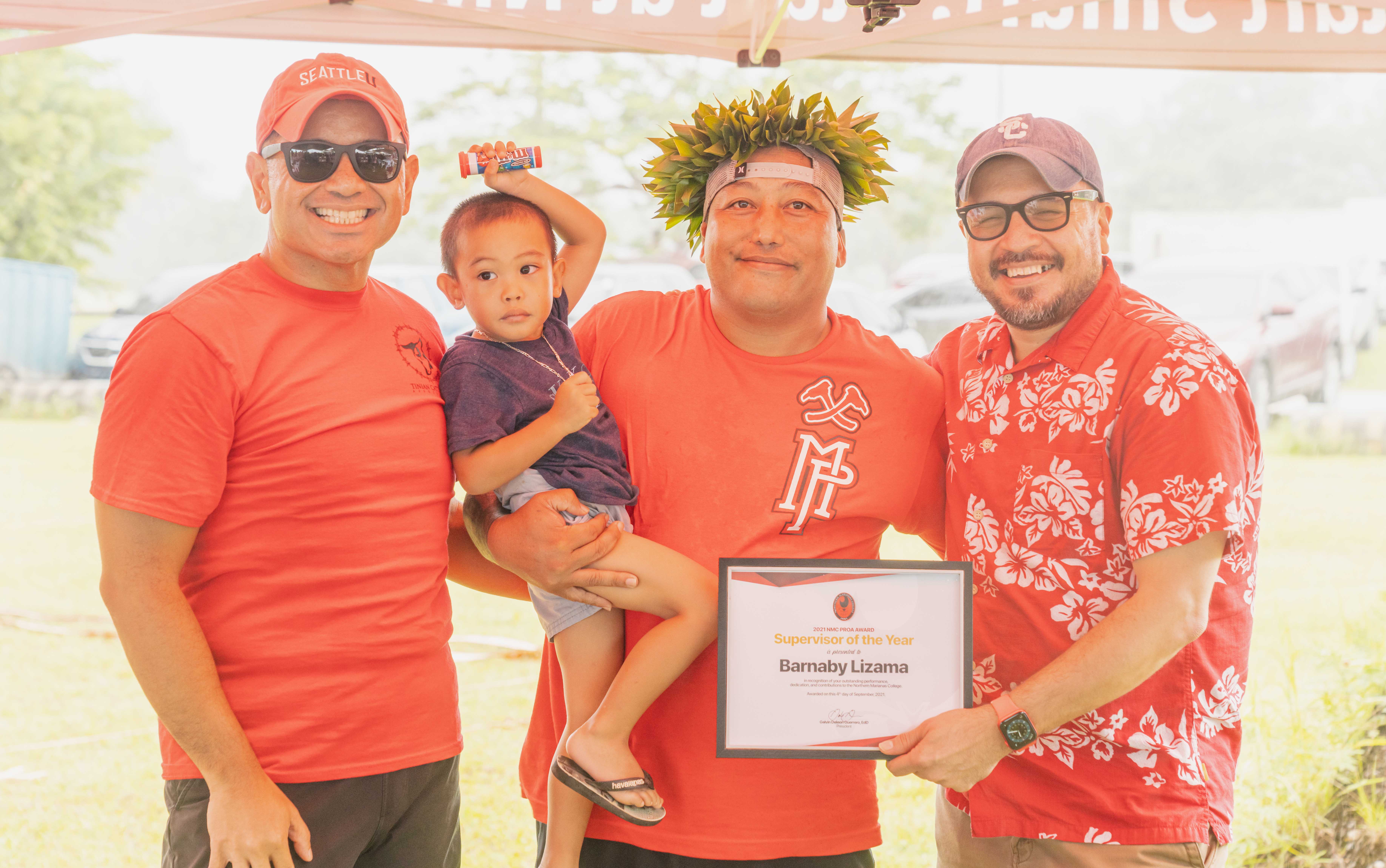 Barnaby Lizama, center,  was awarded the NMC Supervisor of the Year award. In photo with Lizama is his son Josiah, NMC Vice President for Administration and Advancement Frankie Eliptico, left, and NMC President Galvin Deleon Guerrero, right.
