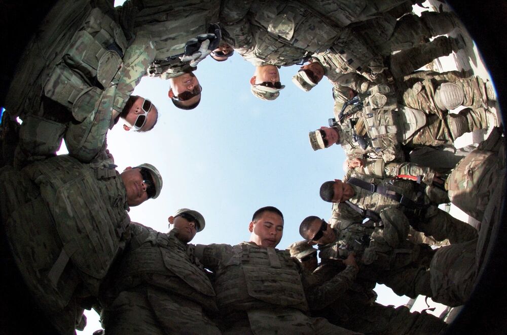 U.S. soldiers with the Guam Army National Guard lock arms in prayer prior to a mission in Lashkar Gah, Helmand province in Afghanistan on July 19, 2013.