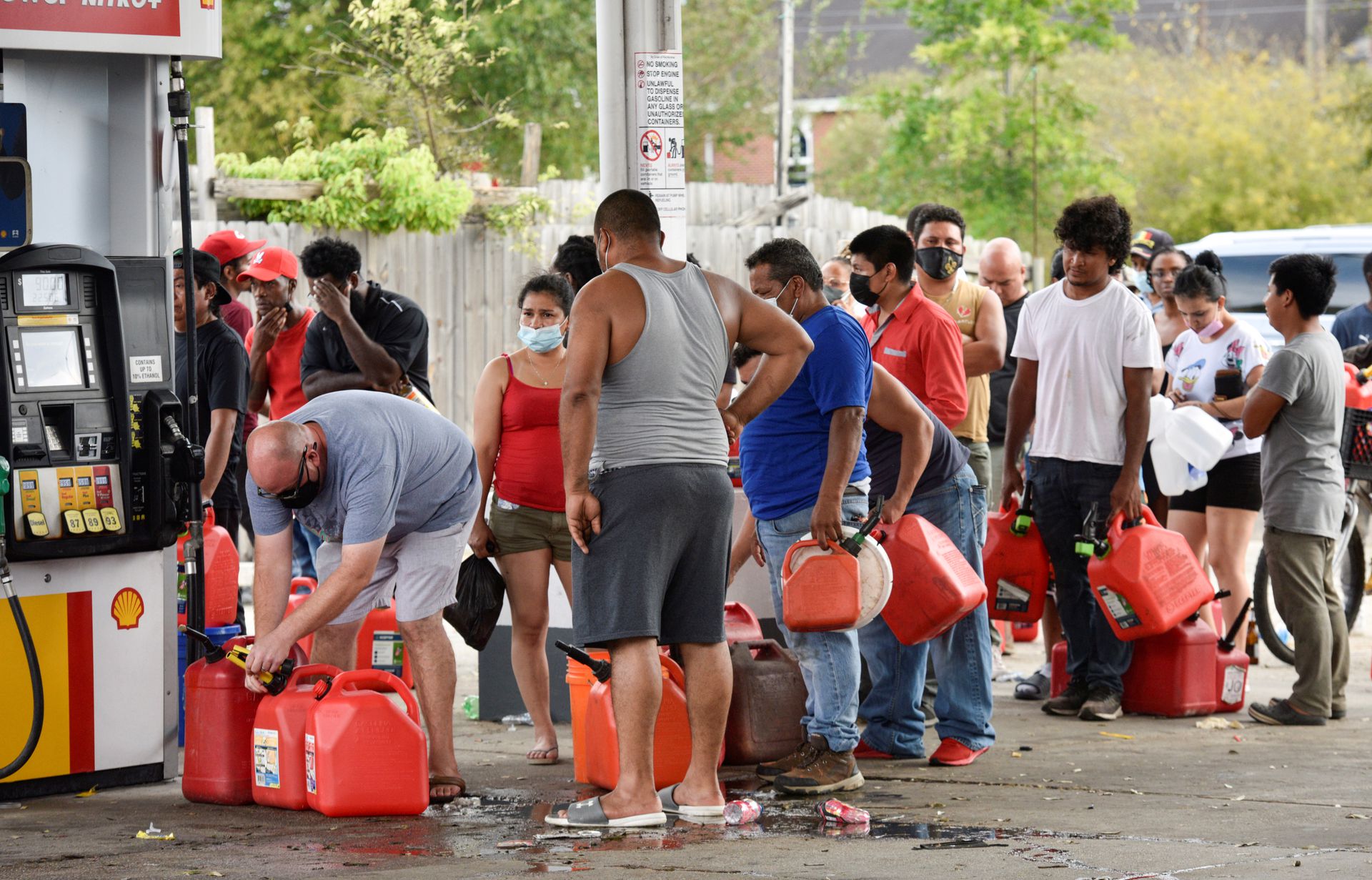 Three days after Hurricane Ida knocked out power throughout the city, residents wait in long lines at a neighborhood gas station to fill fuel containers for cash only sales in New Orleans, Louisiana on Aug. 31, 2021.