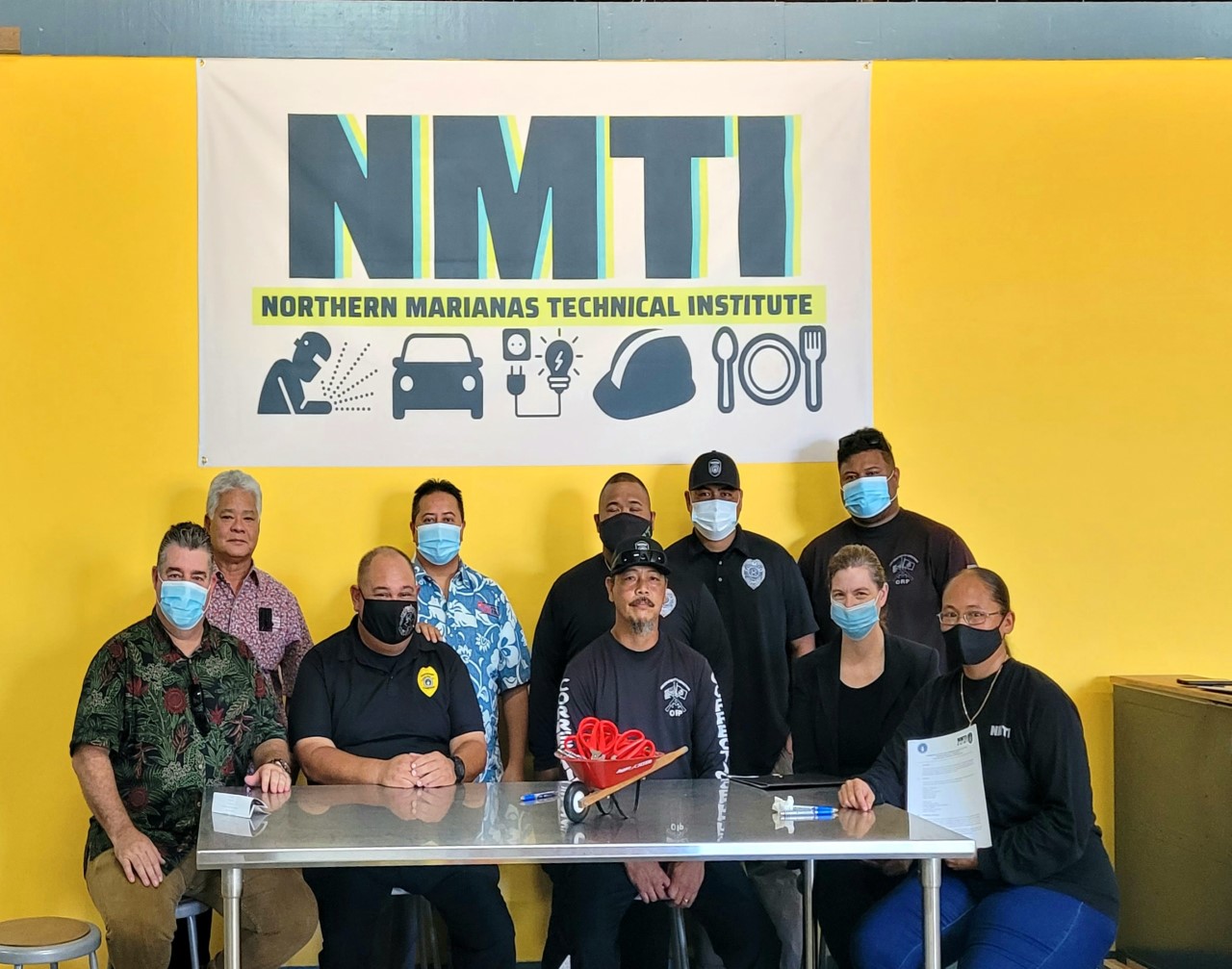 Gov. Ralph DLG Torres, Lt. Gov. Arnold I. Palacios, CNMI Department of Corrections Commissioner Wally Villagomez, Sgt. Jeff Quitugua, Corrections legal counsel Leslie Healer, and other Corrections representatives are flanked by NMTI board chair Mario Valentino and NMTI interim CEO Jodina Attao for a photo following the signing of a program outreach agreement between Corrections and NMTI.