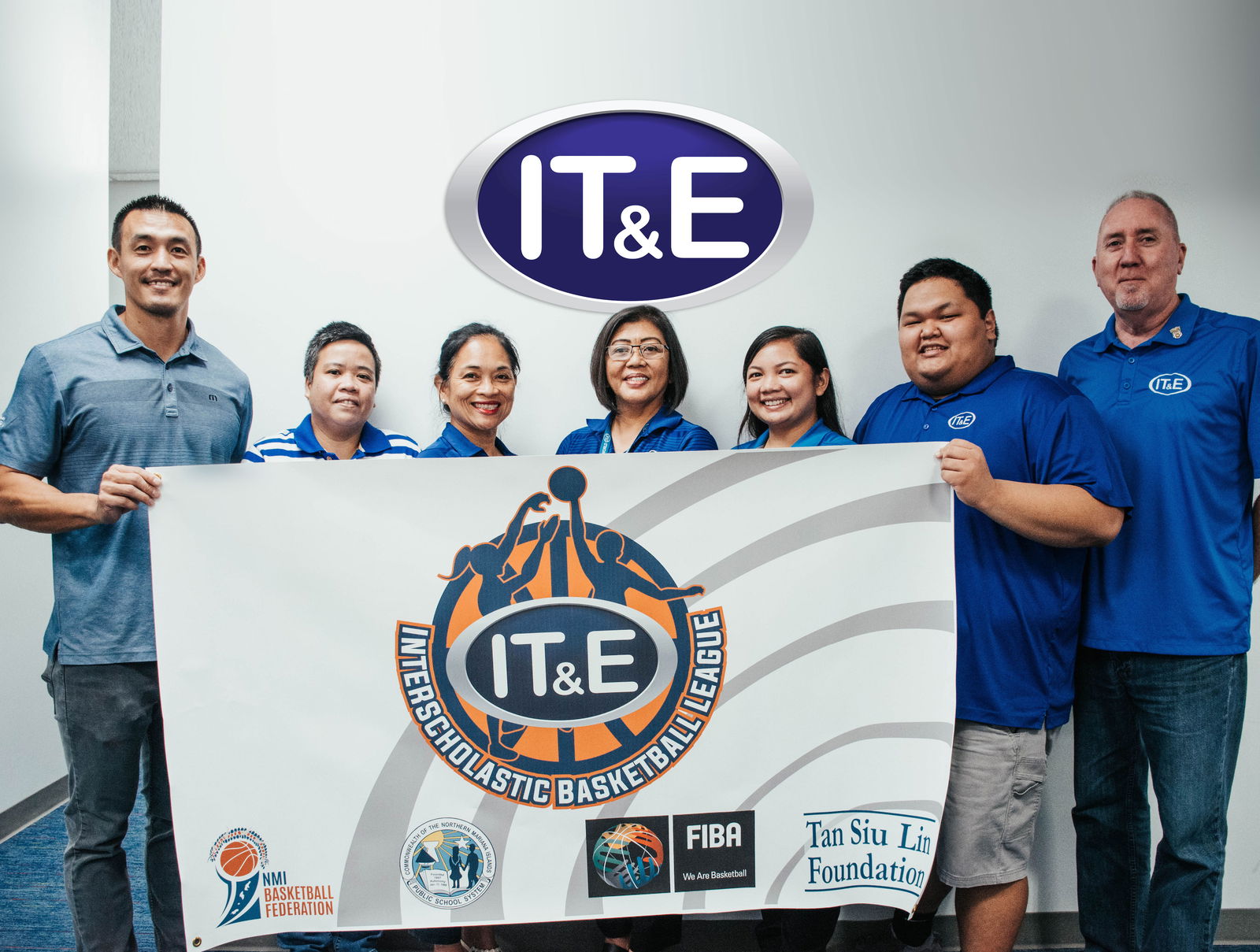IT&E CNMI general manager Rose Soledad, center, IT&E executive director for customer operations Rob Harrel, right, and director of network operations and engineering Velma Palacios, third left, pose for a group photo with Northern Mariana Islands Basketball Federation officials, led by president James Lee, left, at the IT&E office in Susupe to formalize IT&E’s title sponsorship of the interscholastic basketball league 2021-2022 season.