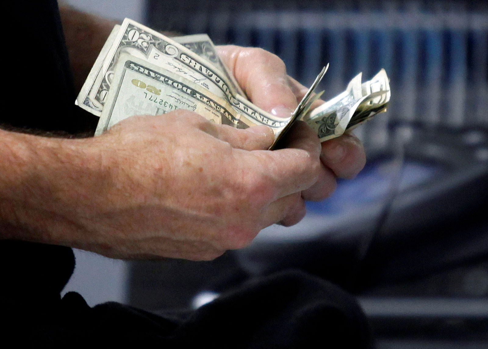 A customer counts his cash at the register while purchasing an item at a Best Buy store in Flushing, New York on March 27, 2010.
