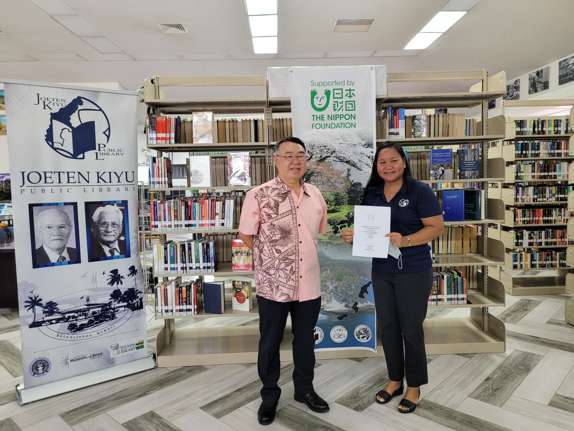 Joeten-Kiyu Public Library Director Erlinda Naputi holds ceremonial document while posing for a photo with Japan Consul Kazuhiko Ono at JKPL on Tuesday.