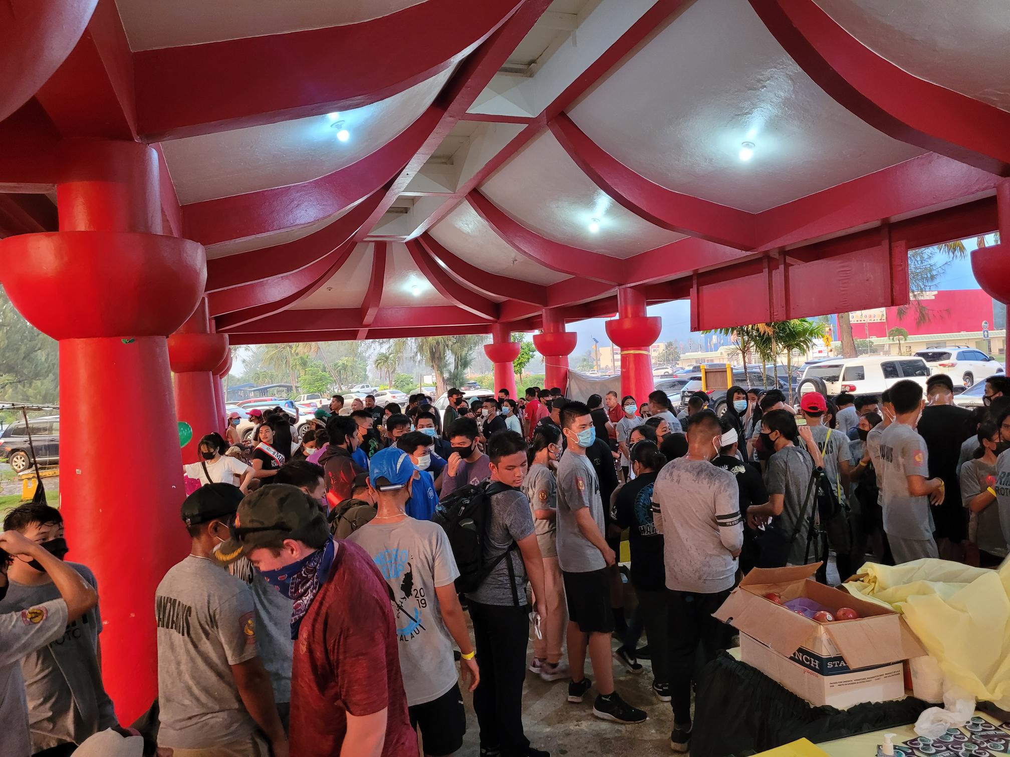 Students and community members take shelter at the Minachom Atdao pavilion during a sudden downpour on Thursday.  They were among the participants of the Light Up the Night Walk to raise awareness on suicide prevention.