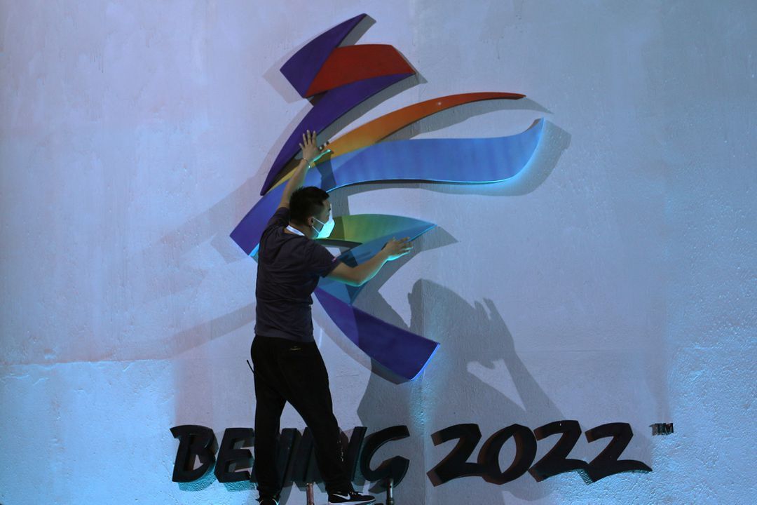A man adjusts an emblem of the Beijing 2022 Winter Olympic Games before a ceremony unveiling the slogan, in Beijing, China on Sept. 17, 2021.