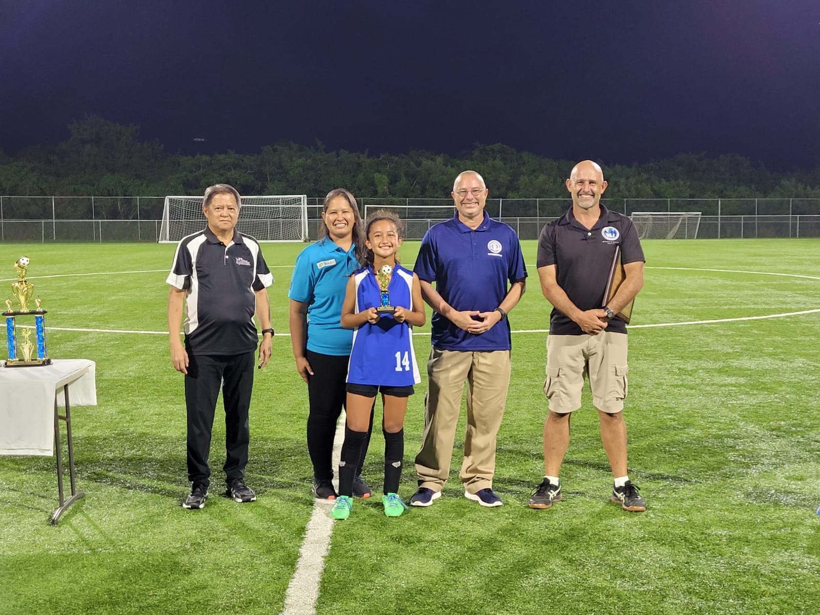 Saipan International School’s Beatrice Gross, the Finals MVP, poses for a photo with NMI Football Association's Ross Zapanta and Catherine Attao-Toves, Board of Education member Greg Borja and Public School System Athletic Program Director Nick Gross during the awards ceremony Wednesday at the NMI Soccer Training Center.