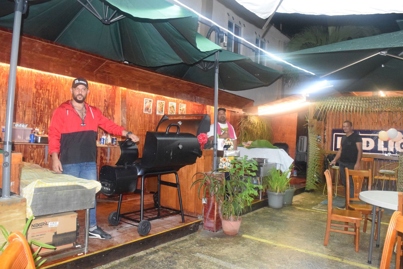 Turkish chef Tuncay, left, and Joaquin Dowai, center, stand next to their  grills at the Ice Island Outdoor Bar & Grill in Garapan on Saturday