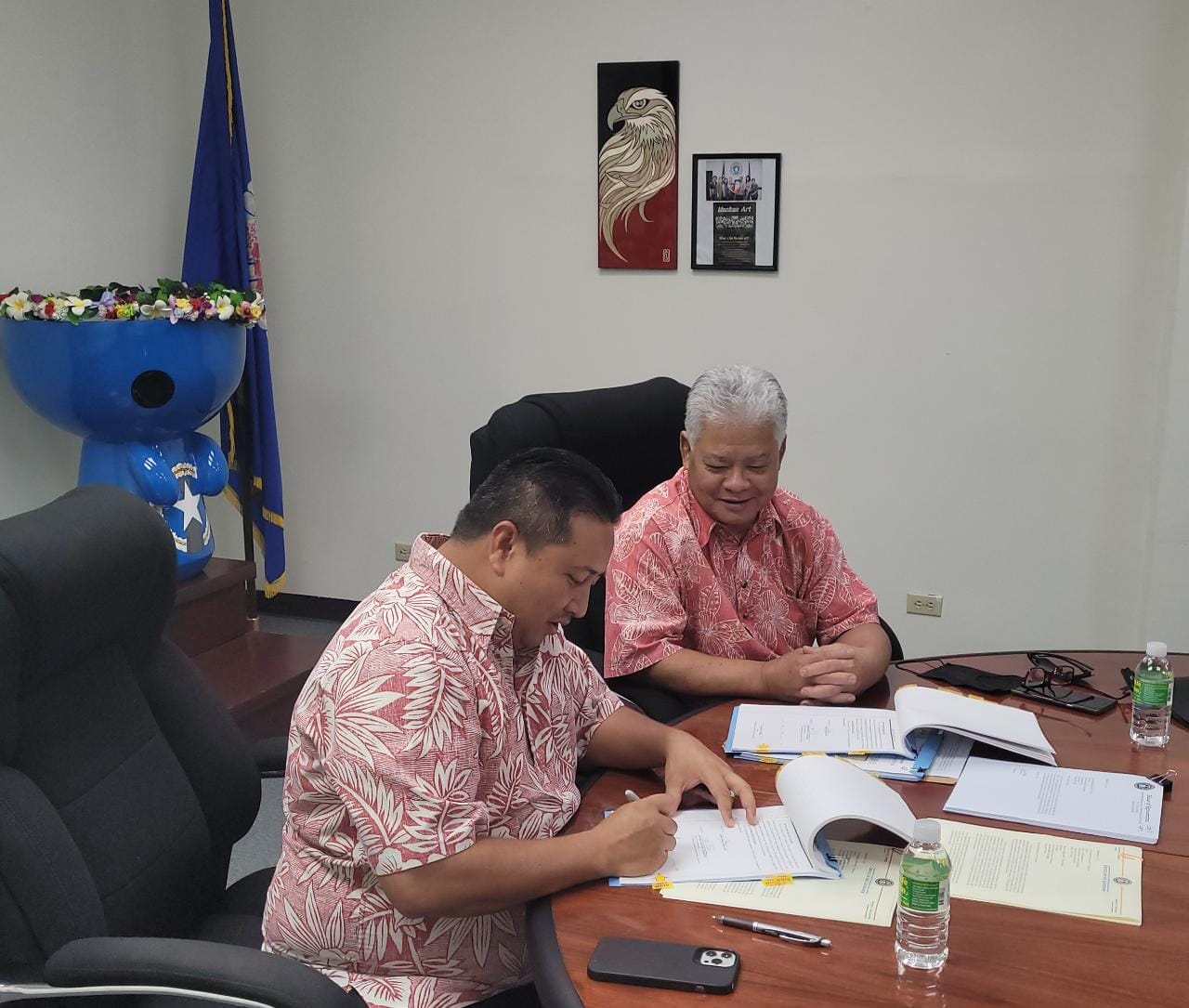 Gov. Ralph DLG Torres, left, signs the fiscal year 2022 budget bill as Lt. Gov. Arnold I. Palacios looks on in the governor's conference room Thursday on Capital Hill.