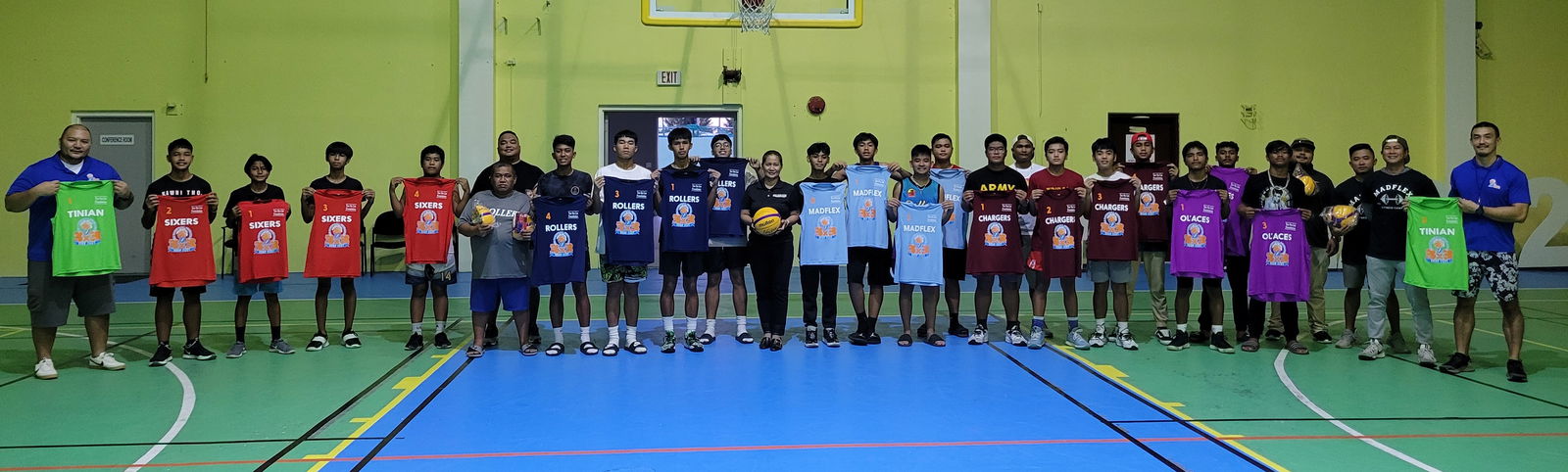 Players and coaches participating  in the NMIBF 3x3 Hoop Fest pose with Tan Siu Lin Foundation executive director Merlie Tolentino, 11th left, and Northern Marianas Islands Basketball Federation officials during the jersey donation turnover ceremony Thursday at the Gilbert C. Ada Gymnasium.