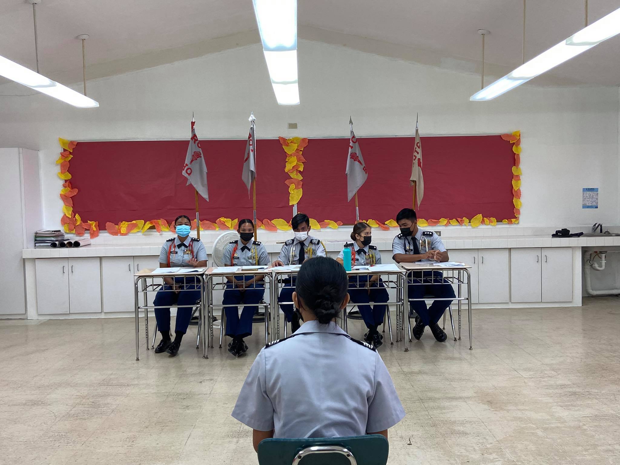 A cadet answers questions from high-ranking officers.