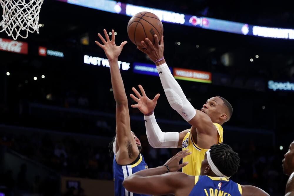 Los Angeles Lakers guard Russell Westbrook shoots as Golden State Warriors guard Moses Moody, rear, defends during the first half of an NBA basketball game in Los Angeles, Tuesday.