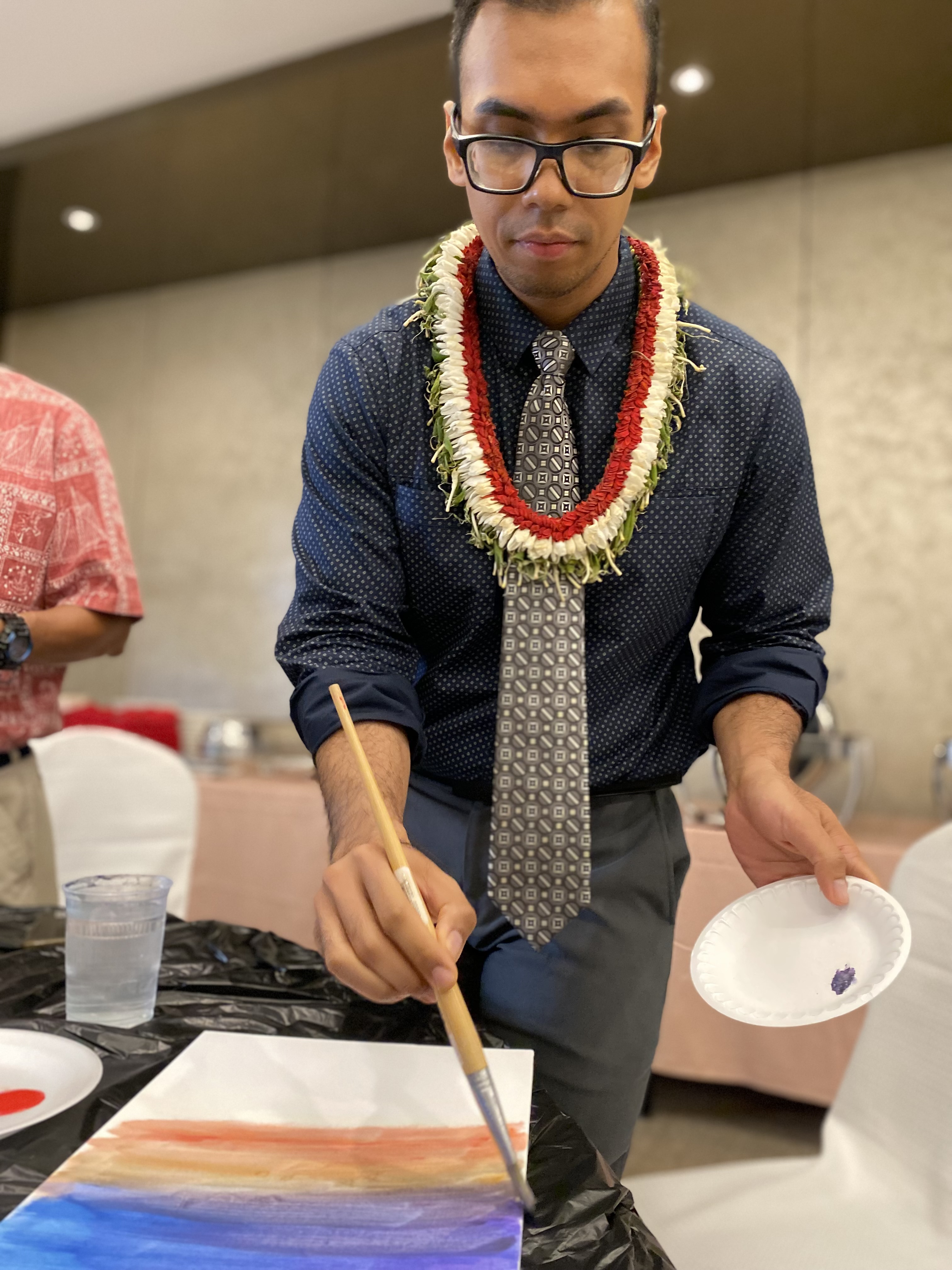 Principal Jonathan Aguon of Marianas High School applies color to his painting.