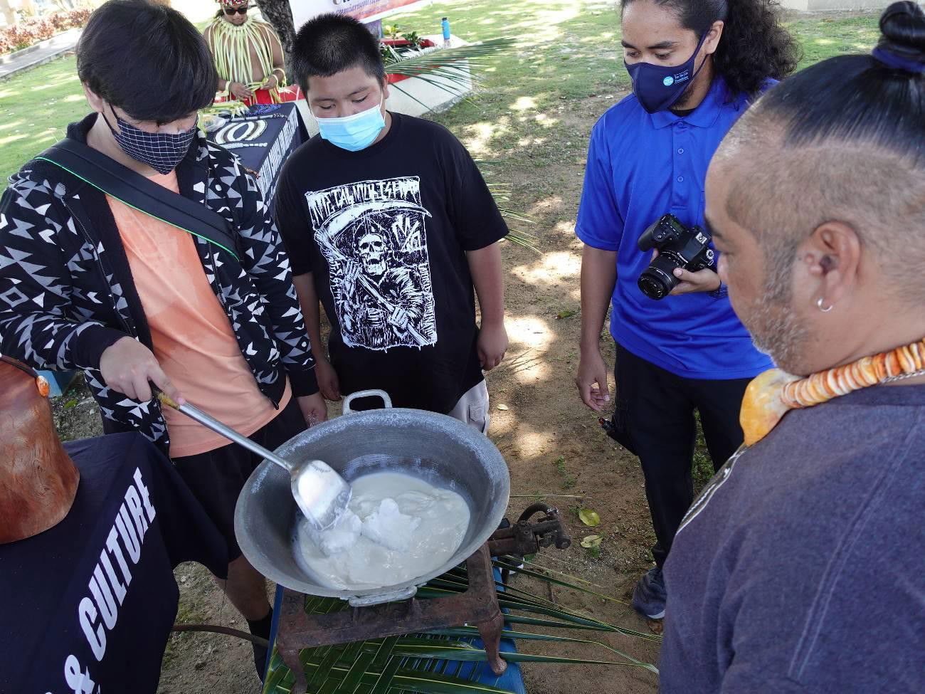 Mike Naputi, right, teaches coconut oil making to students of Marianas Youth Welcome All Visitors Enthusiastically or MY WAVE Clubs of Kagman High School and Saipan Southern High School in Garapan, Saipan on Sept. 27, 2021, in celebration of World Tourism Day.