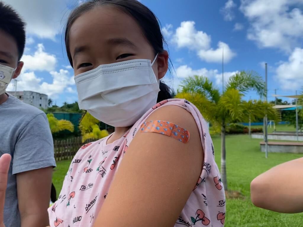 A Saipan International School student shows off her vaccination Band-Aid.