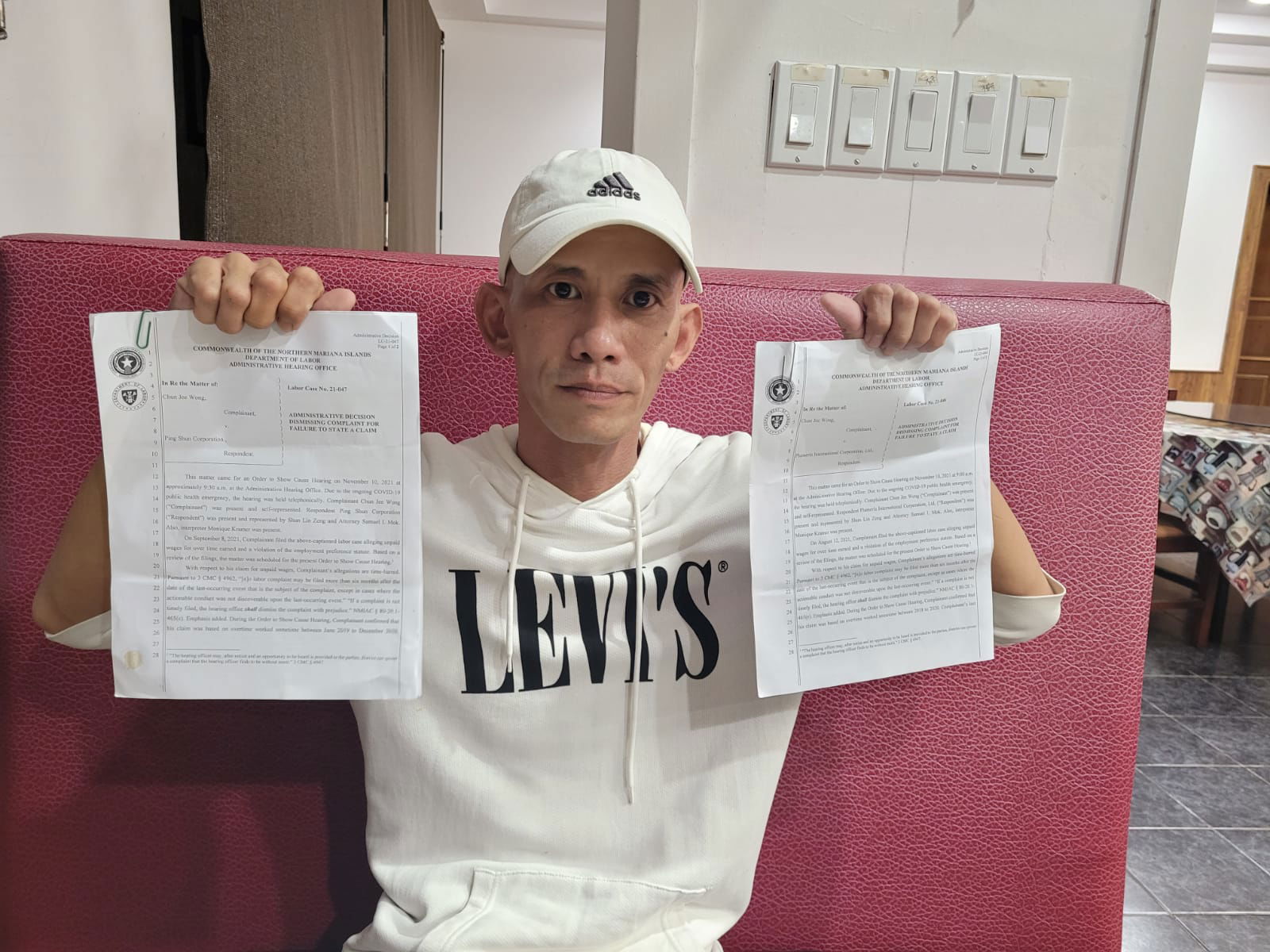 Chun Jee Wong holds copies of CNMI Labor's decision on his complaint during an interview with Variety on Friday.
