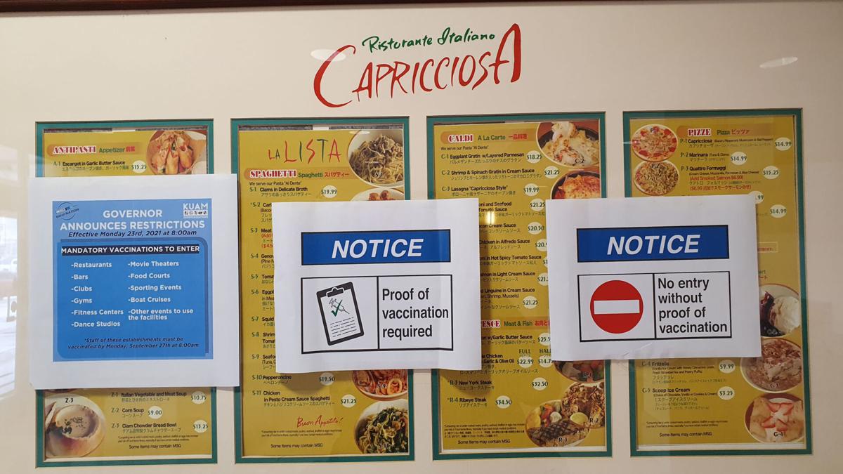 Signage at the entrance to Capricciosa Ristorante Italiano informs customers that because of the governor's executive order they will have to show proof of vaccination, as seen on Aug. 24 in Hagåtña.