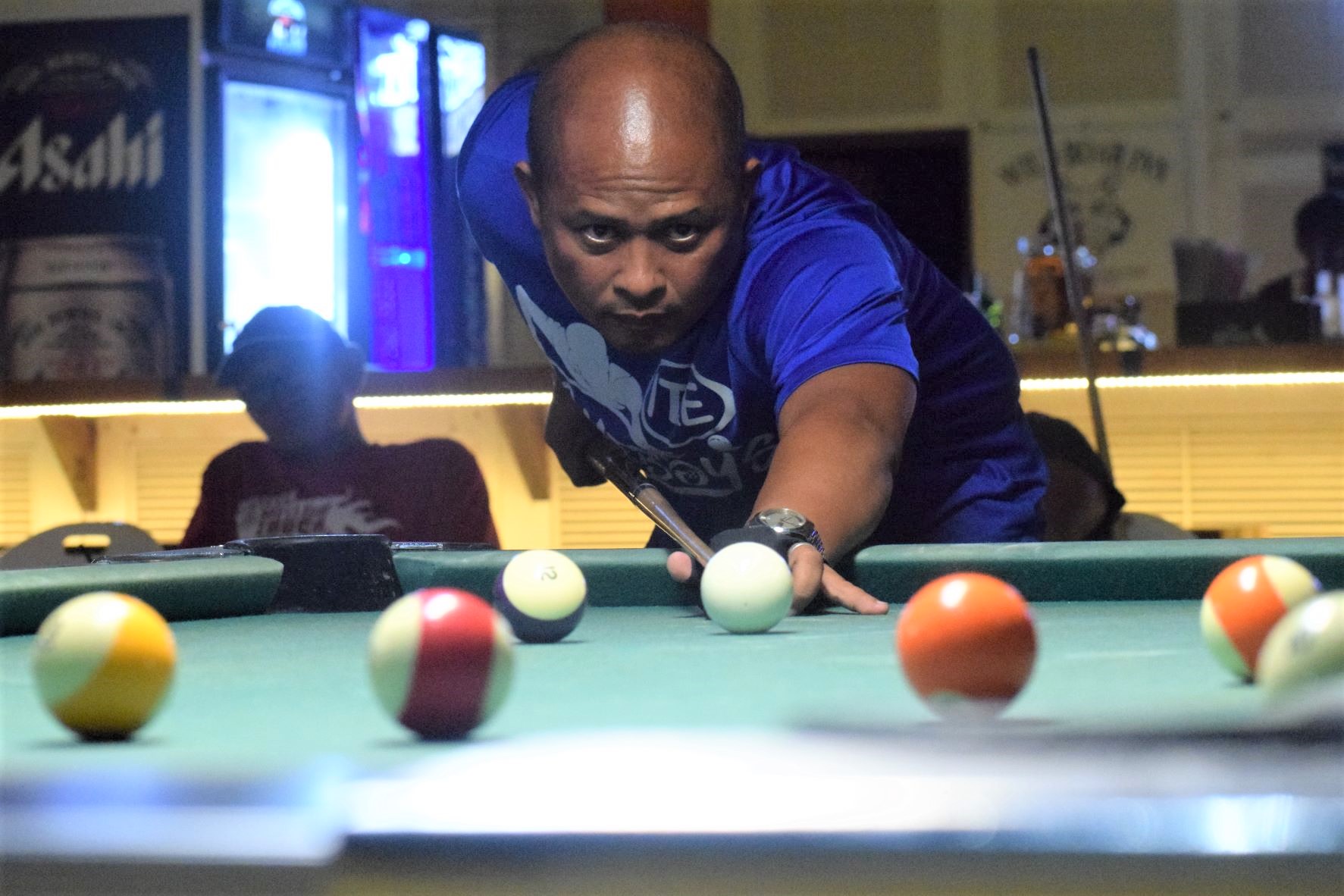 IT&E Destroyers'  Rolly Villanueva aims at the 5-ball during the Tuesday Division championship match of the Saipan Billiards Association's Budweiser Open 8-Ball League at Last Shot Bar Tuesday night.