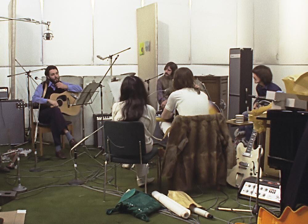 Background from left, Paul McCartney, Ringo Starr and George Harrison, and foreground from left, Yoko Ono and John Lennon in a scene from the nearly 8-hour Peter Jackson-produced documentary “Get Back,” airing over three days starting Thanksgiving.