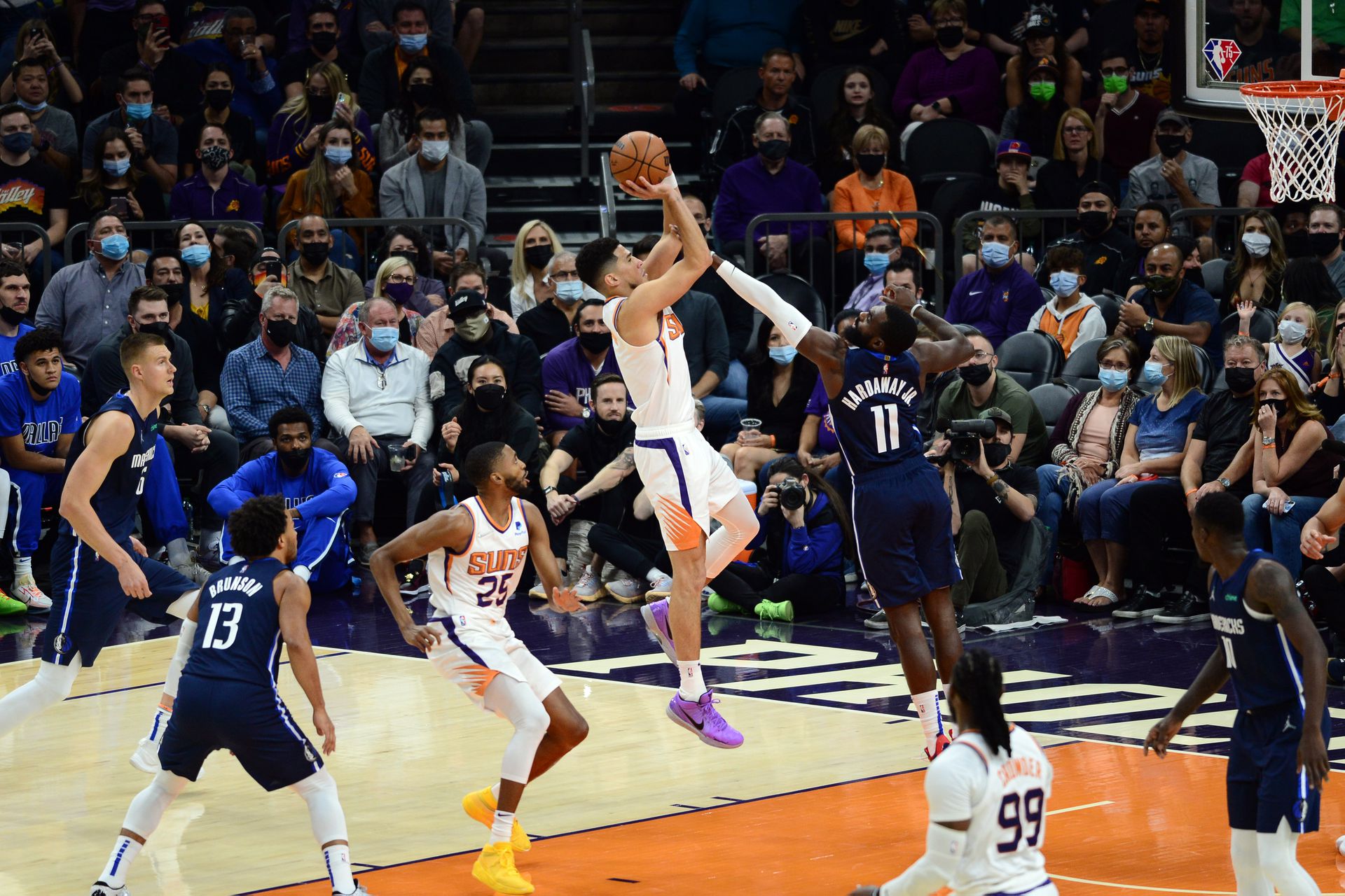 Phoenix Suns guard Devin Booker (1) shoots over Dallas Mavericks forward Tim Hardaway Jr. (11) during the first half at Footprint Center in  Phoenix, Arizona on  Nov. 17, 2021.