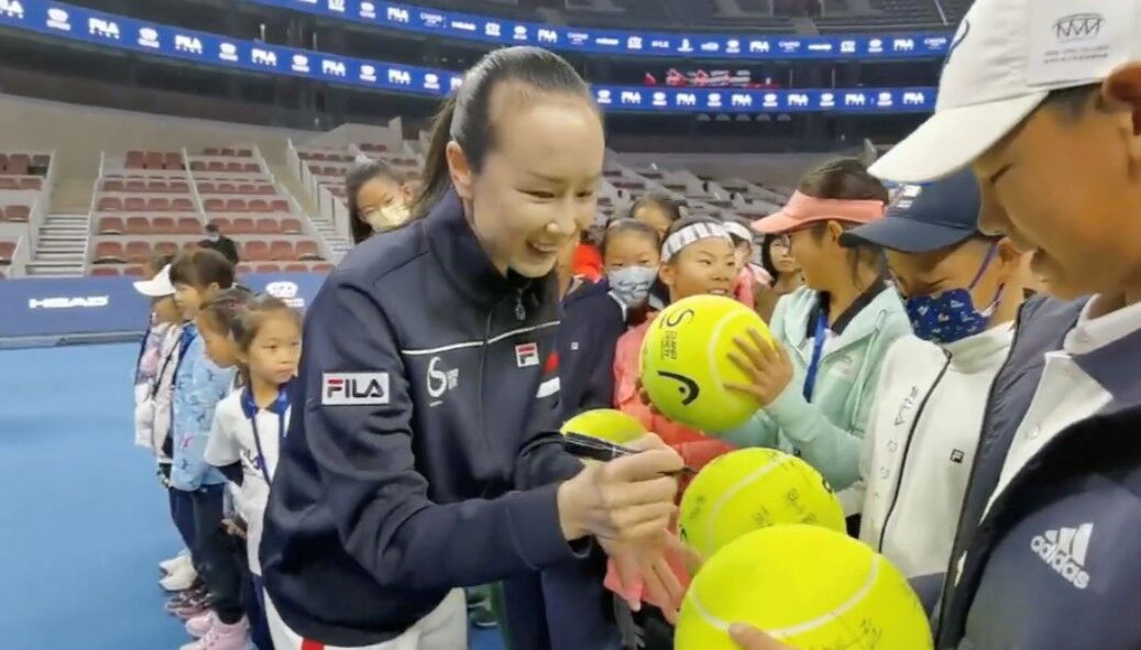 Chinese tennis player Peng Shuai signs large-sized tennis balls at the opening ceremony of Fila Kids Junior Tennis Challenger Final in Beijing, China on Nov. 21, 2021, in this screen grab obtained from a social media video.