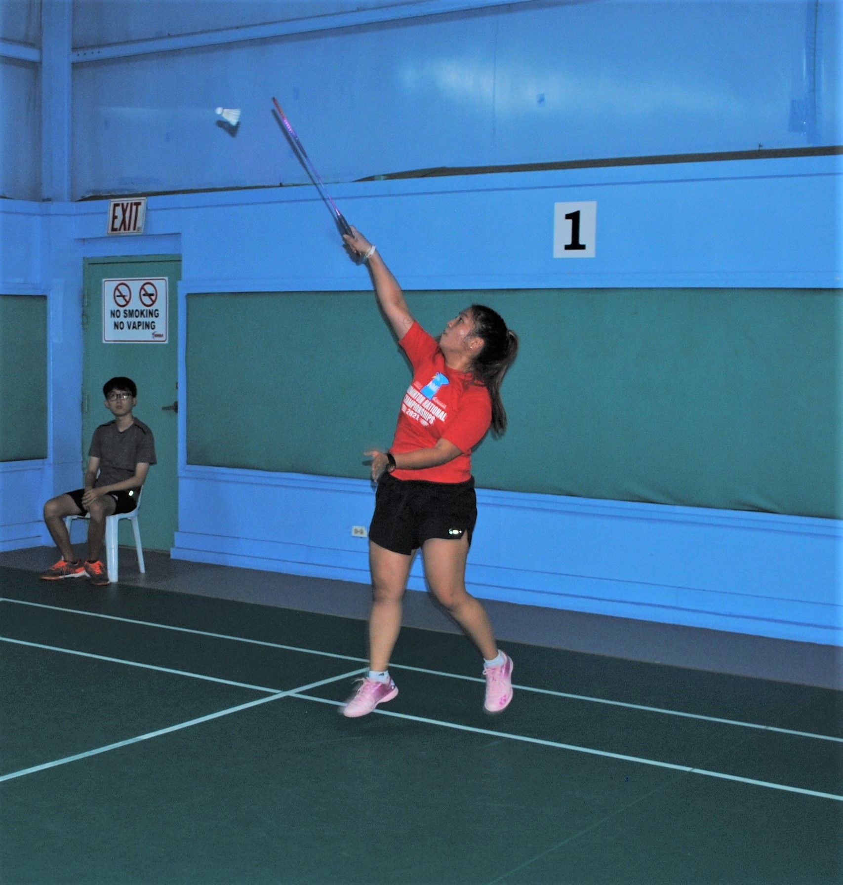 Janelle Pangilinan attempts a high return during a semifinal game in the women's doubles division of the CNMI Badminton National Championships at the TSL Sports Complex on Friday.