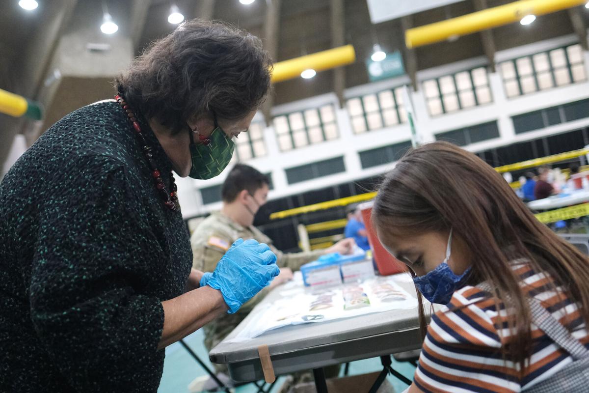 Guam Gov. Lou Leon Guerrero, a registered nurse, administers a dose of the Covid-19 vaccine to her granddaughter, Paloma Cook, Tuesday afternoon at the University of Guam Field House.