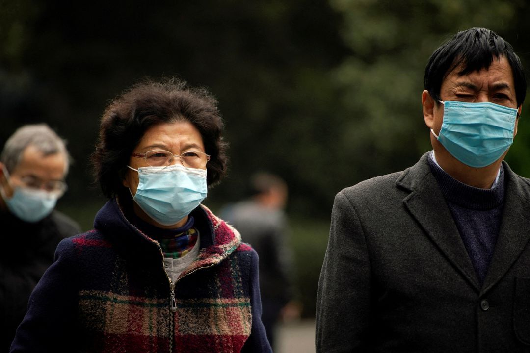 People wearing face masks following the coronavirus disease outbreak walk on a street in Shanghai, China, Dec. 14, 2021.