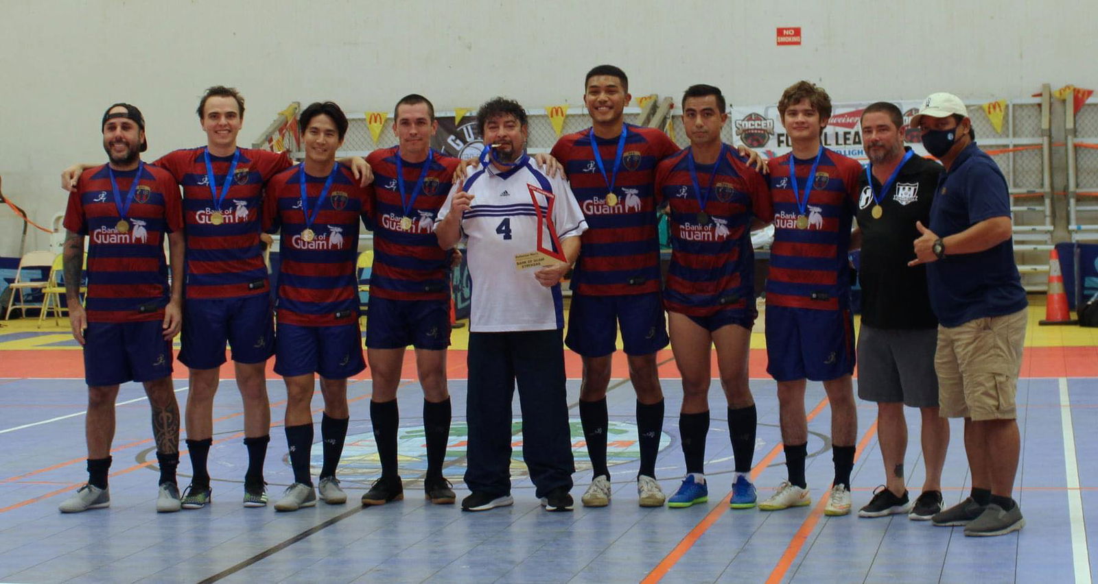 Jehn Joyner, fifth right, poses with the other Bank of Guam Strykers after they won the championship  of the Budweiser Men's Futsal League at Guam’s sports complex on Nov. 22, 2021.