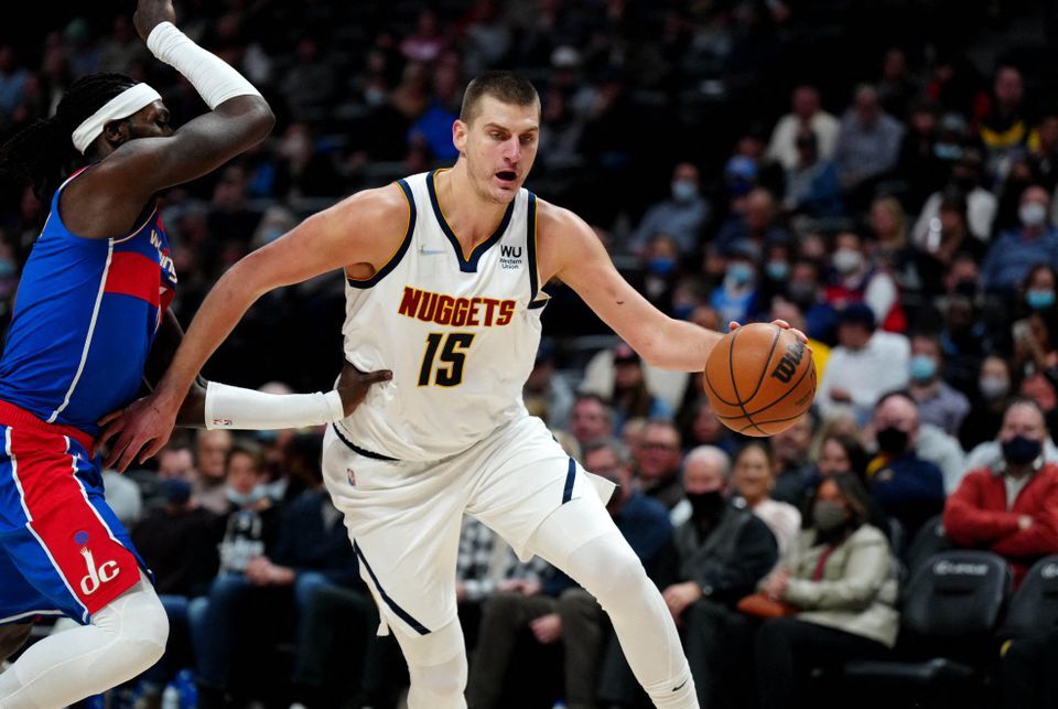 Denver Nuggets center Nikola Jokic (15) dribbles past Washington Wizards center Montrezl Harrell (6) in the second quarter at Ball Arena in Denver, Colorado on Dec. 13, 2021.