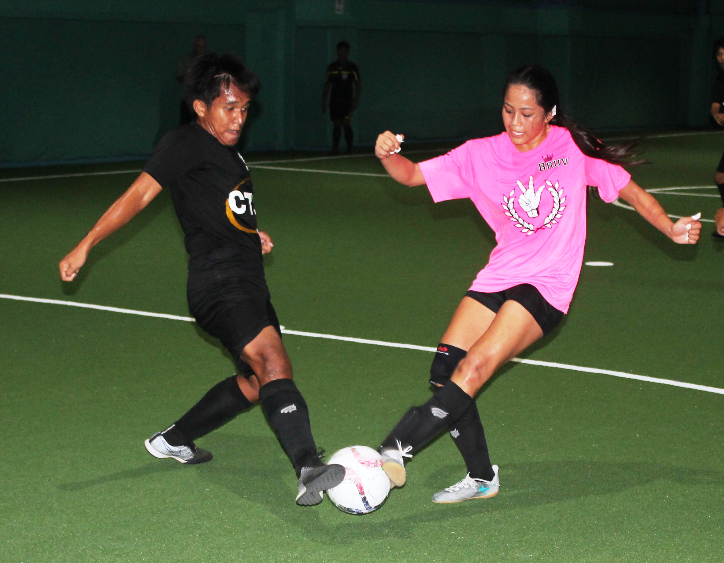 Thaiphi Austria makes contact with the ball as  Guinevere Borja goes for the shot during the finals of the 2018 Youth Futsal Tournament at TSL Sports Complex.