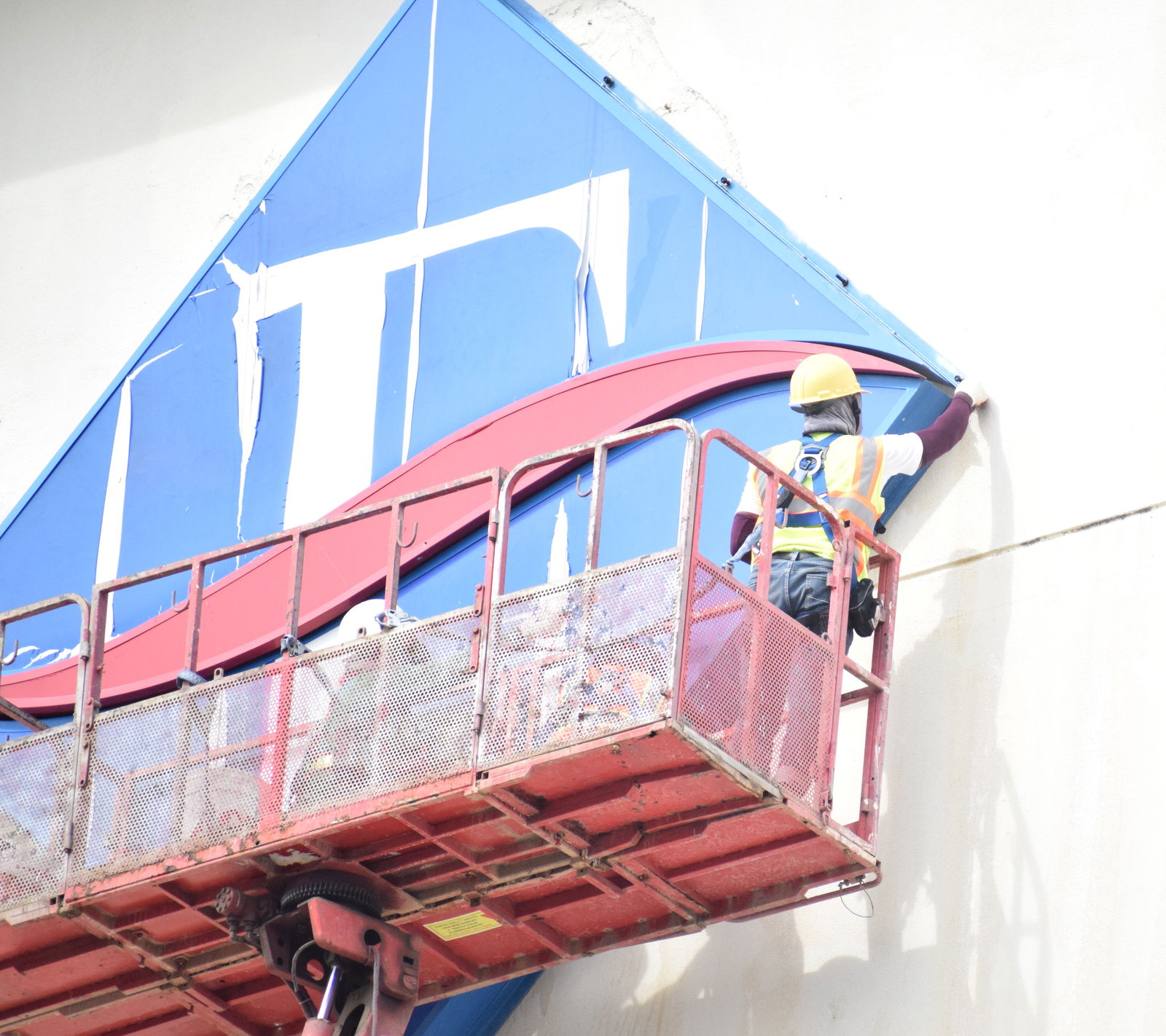 A worker begins removing the Fiesta Resort logo on the hotel’s facade Wednesday morning.