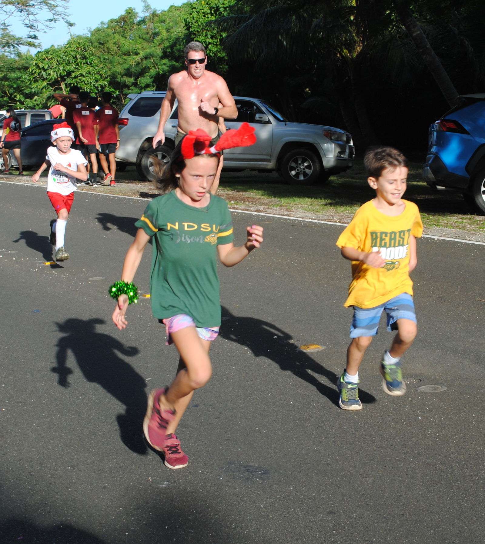 Young — and younger — runners head to the finish line.