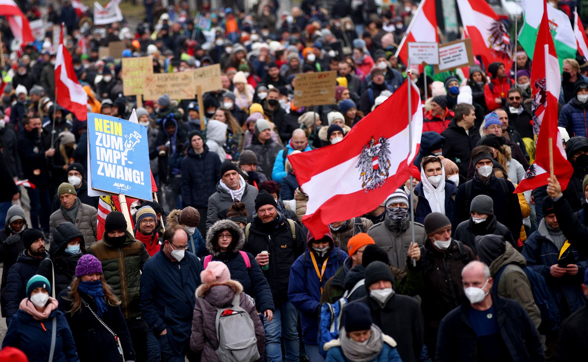Demonstrators hold flags and placards as they march to protest against the coronavirus disease restrictions and the mandatory vaccination in Vienna, Austria, Dec. 4, 2021.