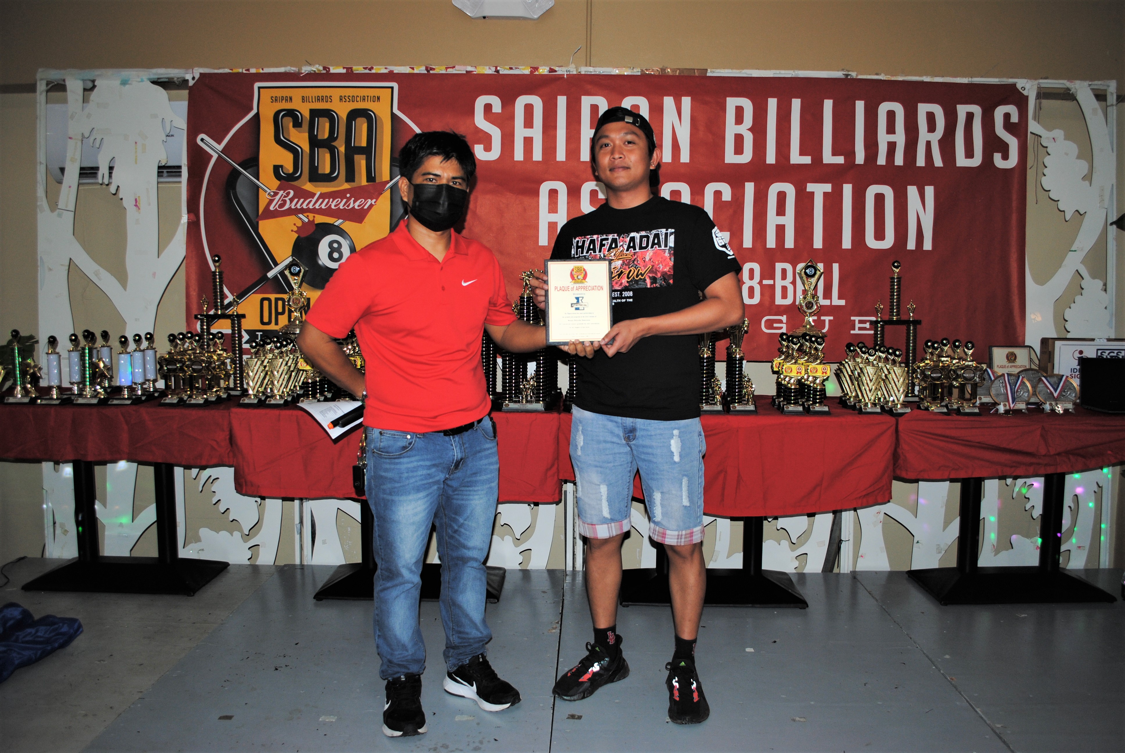 Marpac's Russ Cruz and Pacific Amusement's Warlee Ellama pose for a photo while holding a plaque of appreciation.