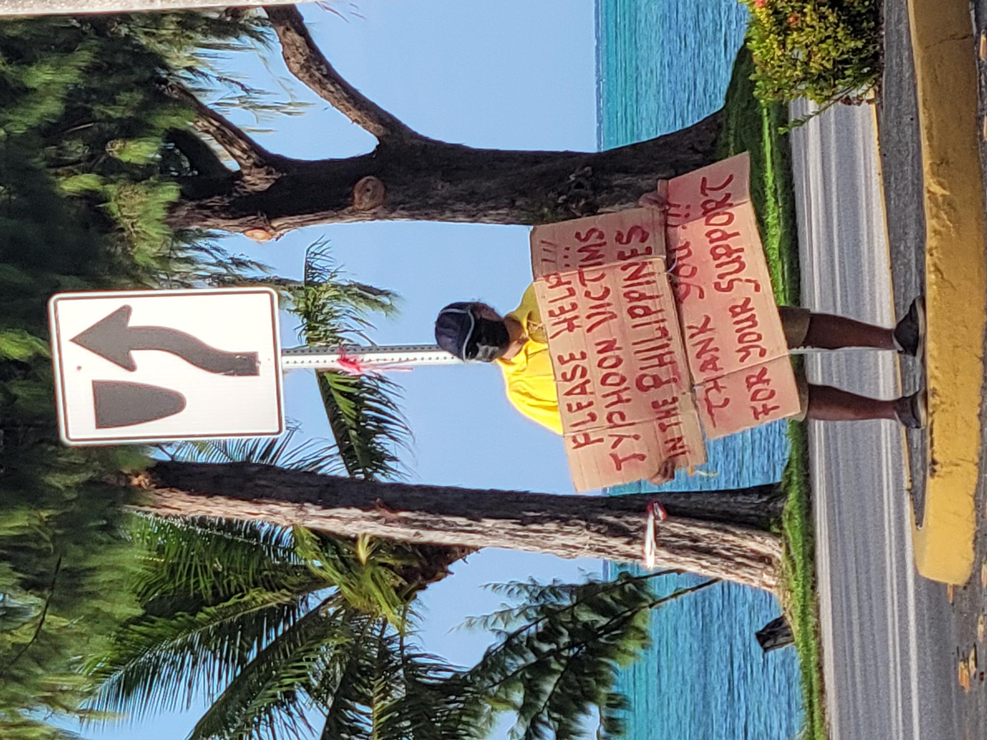 A United Filipino Organization volunteer holds a sign during a roadside fundraising drive for Philippine typhoon victims at the San Jose/Oleai traffic intersection on Friday afternoon.