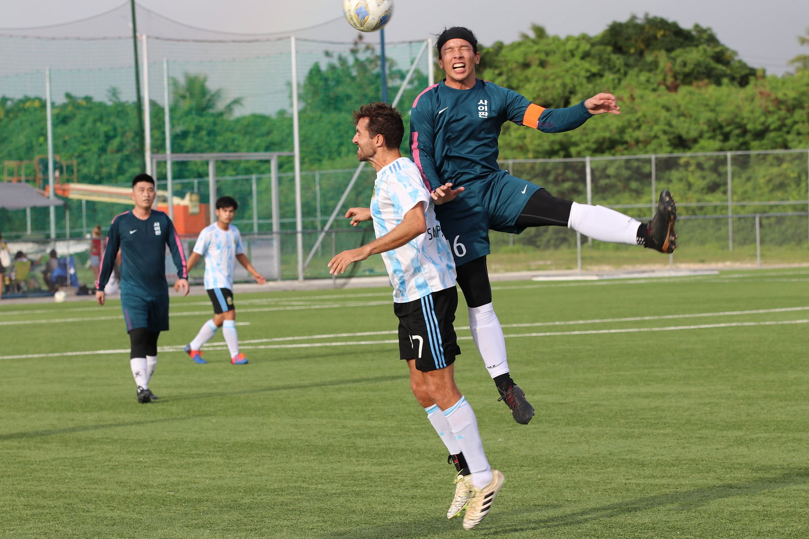 Saipan United's Kelsey McClellan and The One FC's Don Cabrera collide as they attempt a header during the Hafa Adai Fun Cup title game Sunday at the NMI Soccer Training Center.
