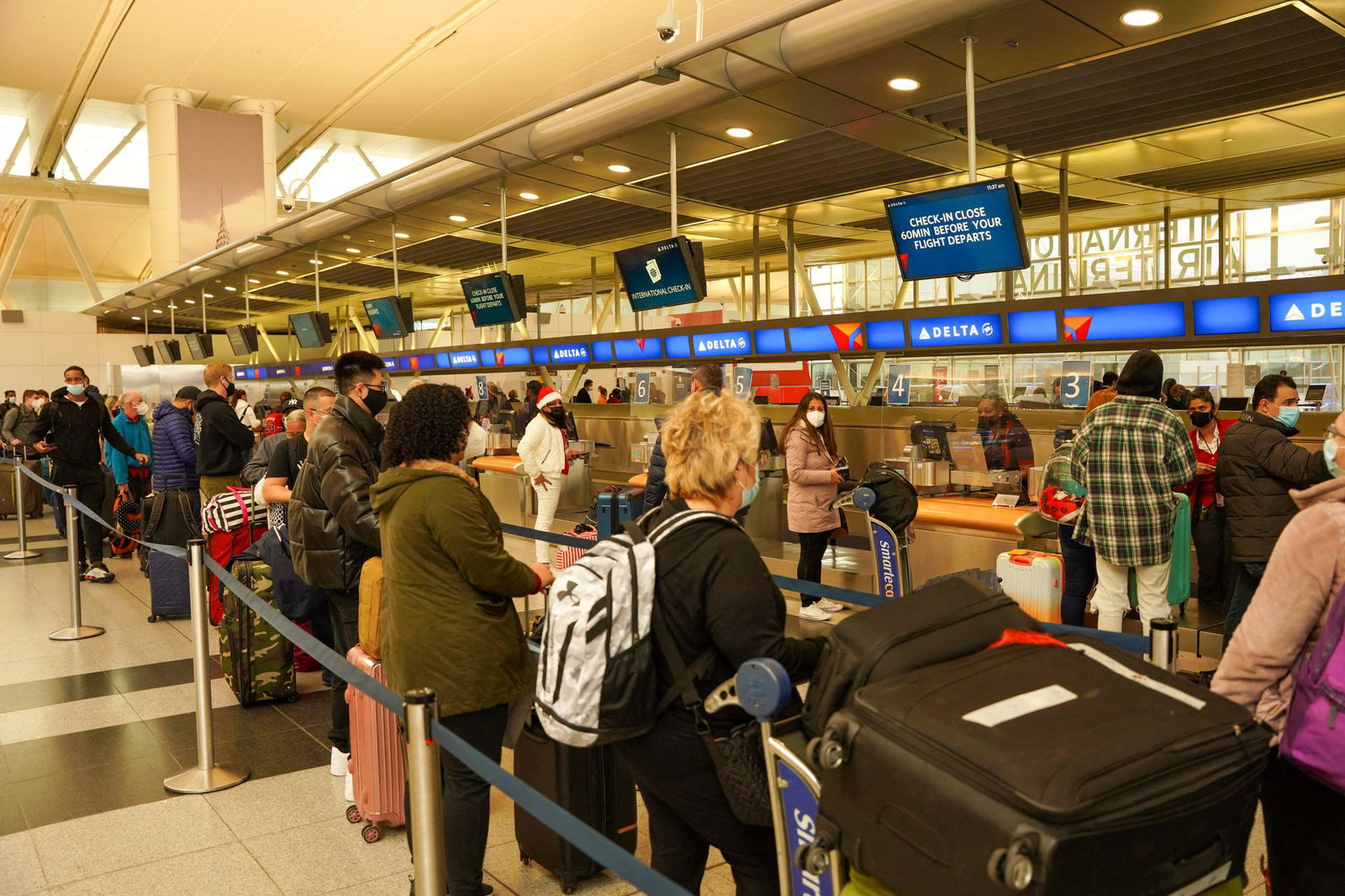Passengers line up at John F. Kennedy International Airport after airlines announced numerous flights were canceled during the spread of the Omicron coronavirus variant on Christmas Eve in Queens, New York City, Dec. 24, 2021.