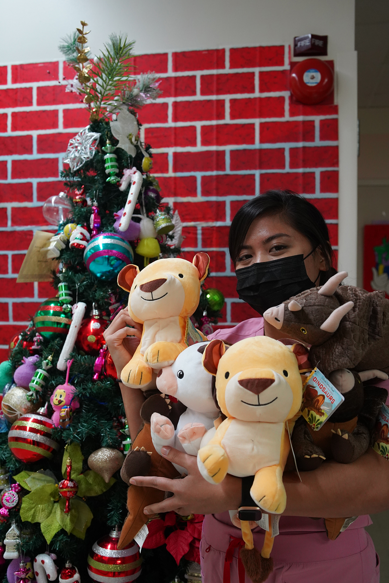 Registered nurse Ella Dela Cruz shows some of the new stuffed animals donated by Taga Riders Motorcycle Club for pediatric patients.